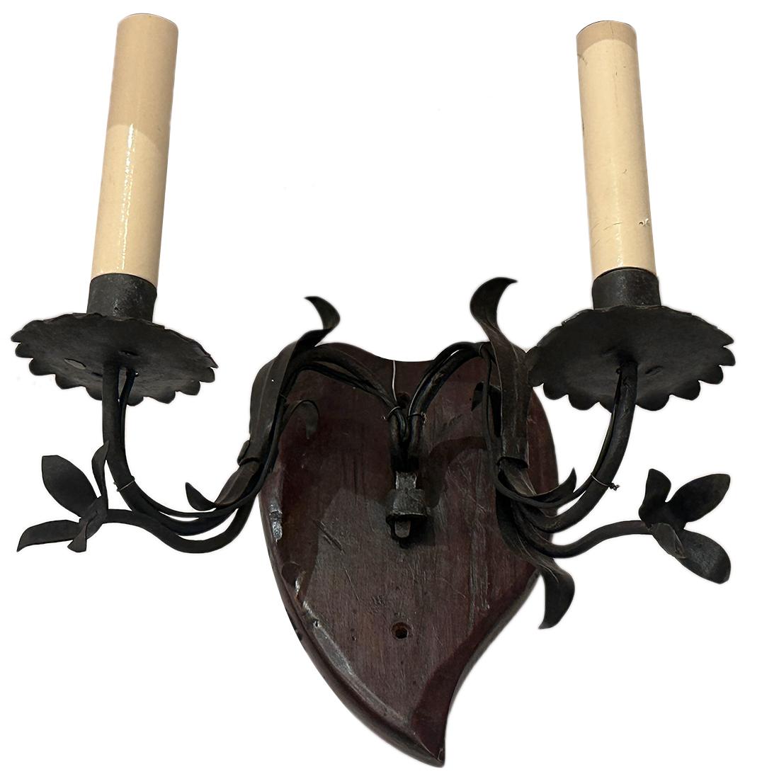 A set of 1920's English hand-carved wood and wrought iron two-arm sconces, backplate made of carved wood, arms of hammered iron, original patina.

Measurements:
Height: 11