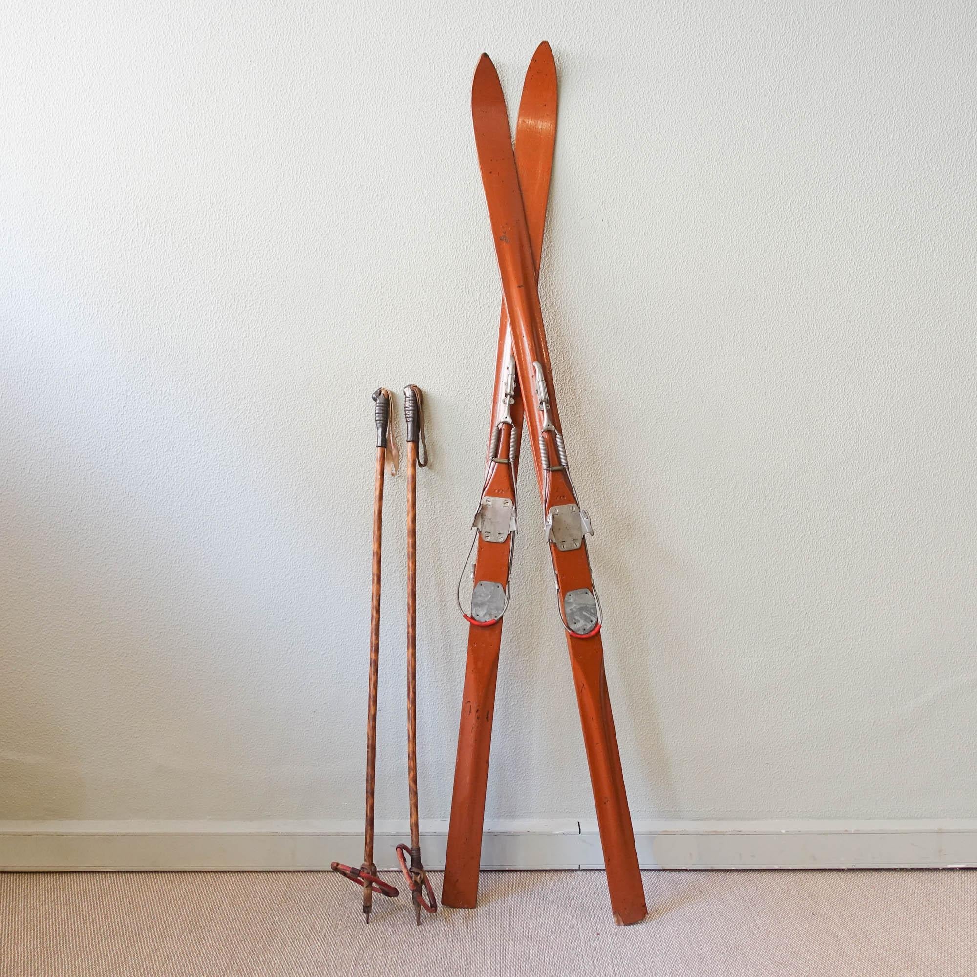 This set of ski equipment, was produced by Heinrich Hammer, in Germany, during the 1930s. These antique skis in painted wood, come with kandahar and geze bindings with antique wood ski poles. The ski poles have the top in rubber with leather loops,