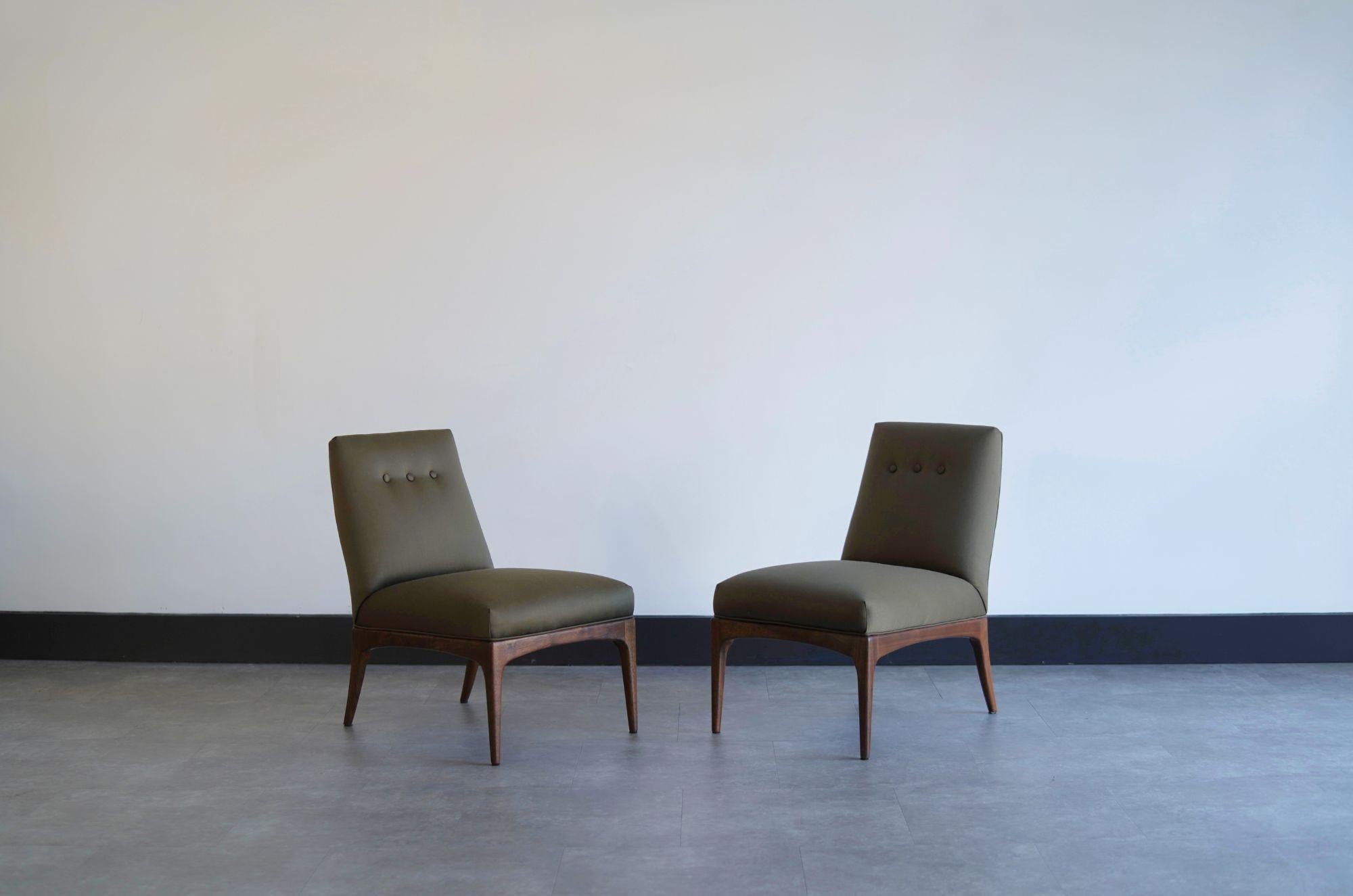 Ensemble de petites chaises pantoufles d'Erwin-Lambeth, vers les années 1950, entièrement restaurées par Stamford Modern. Ces chaises élégantes sont dotées d'un luxueux revêtement en soie vert olive et de sculpturaux pieds sabre en noyer, alliant