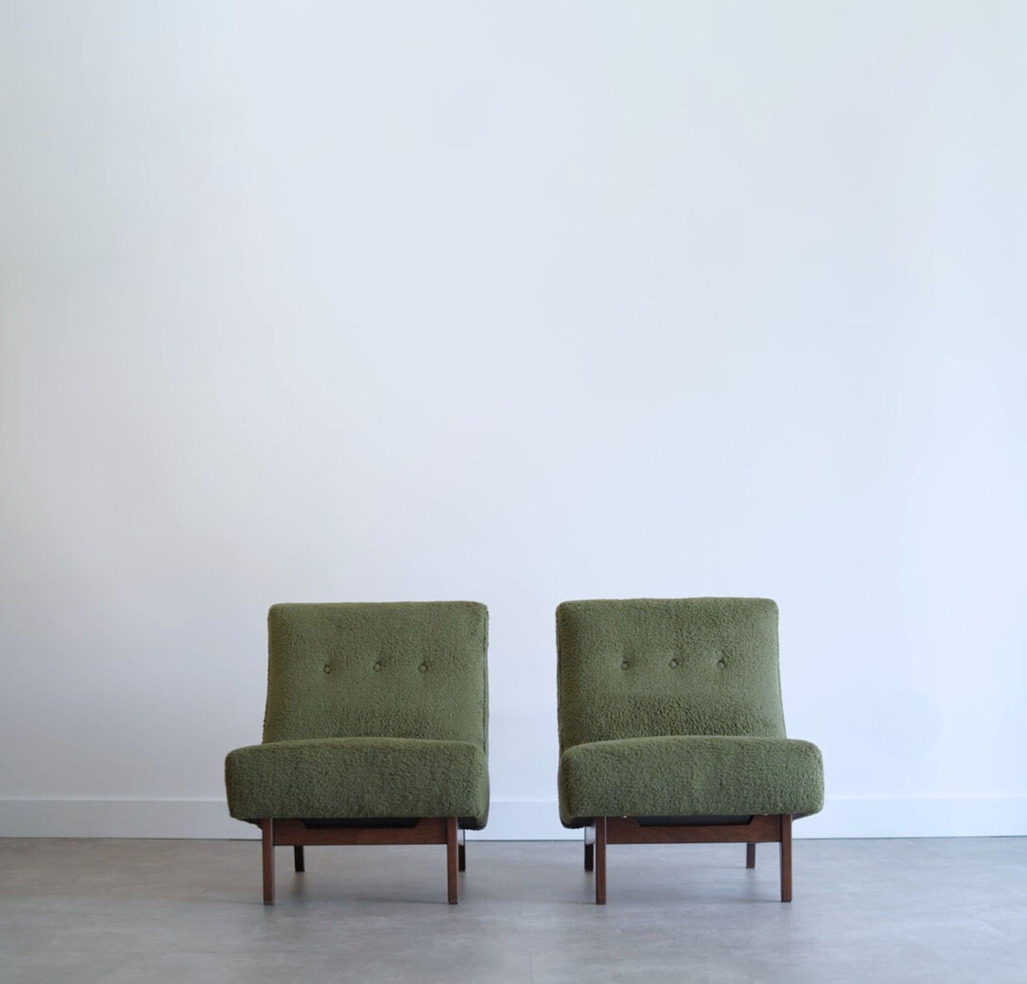 A stunning pair of sculptural slipper chairs by Danish-American designer Jens Risom, circa 1950s, fully restored by Stamford Modern. Featuring low-profile frames in dark walnut and reupholstered in olive green teddy wool, these chairs embody