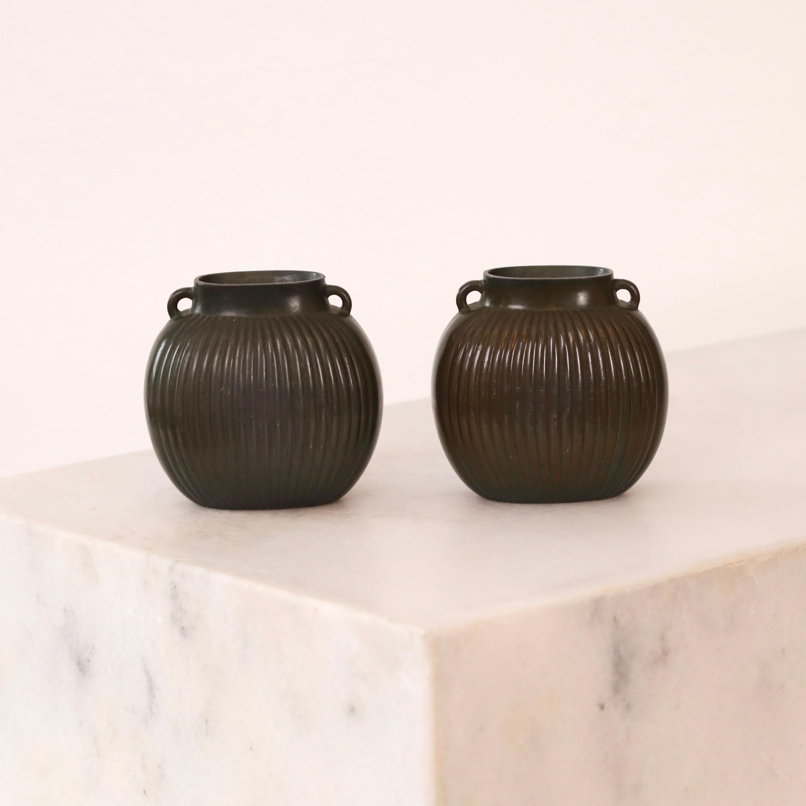 A set of small 1930s metal vases by Just Andersen.  A fine set for a beautiful place.

* A pair (2) of miniature metal vases with vertical lines and lugs
* Designer: Just Andersen
* Style: 1758 (stamped 'Just 1758')
* Year: 1935 
* Condition: Good