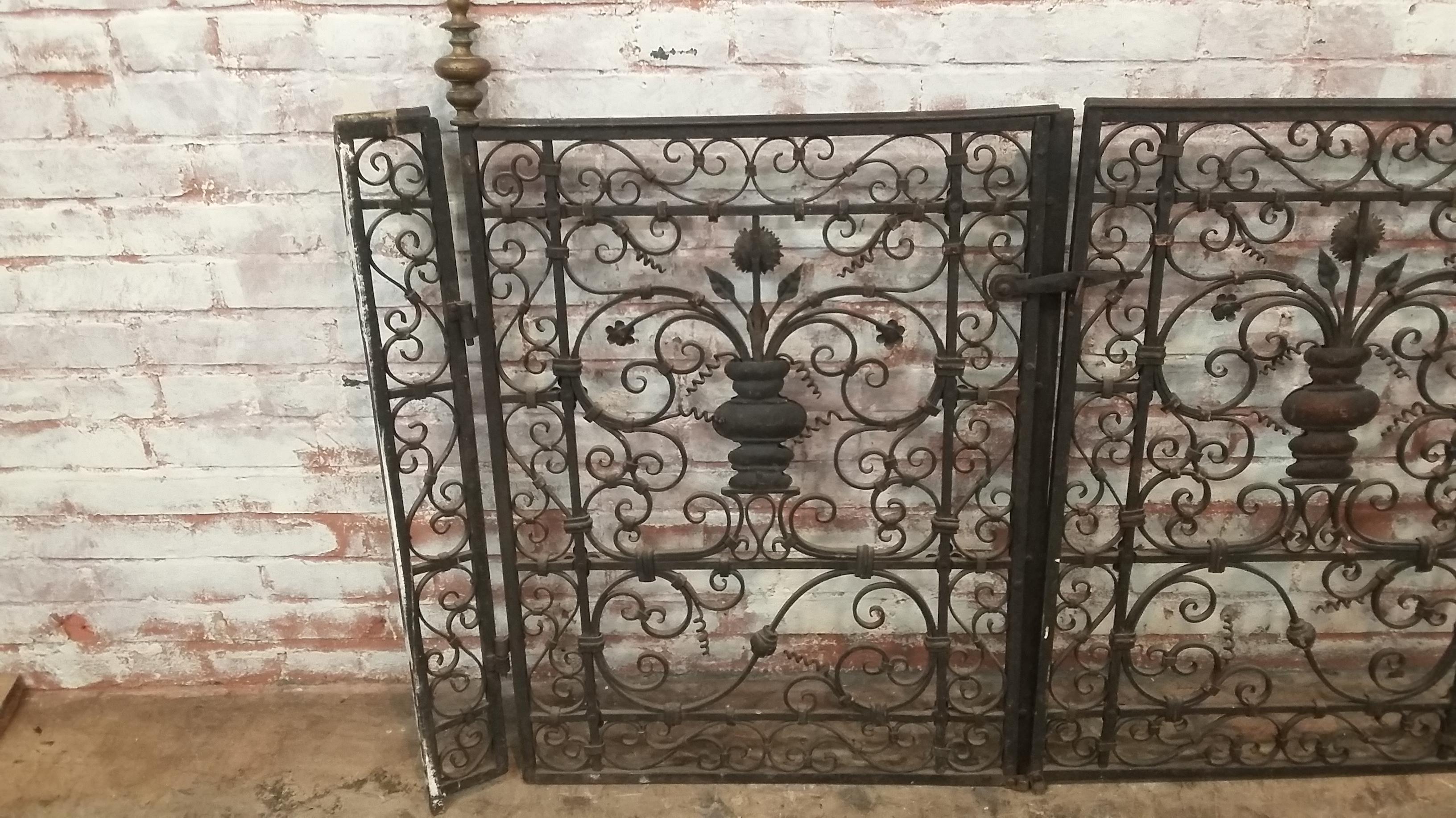 Very ornate set of small wrought iron garden gates. Decorative urn with flowers in the center. Great workmanship on the set. Each side has a small return 4