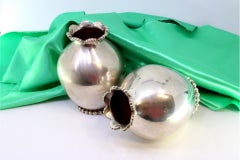 Set of smooth, round silver jugs with pearls on the rim and circular base