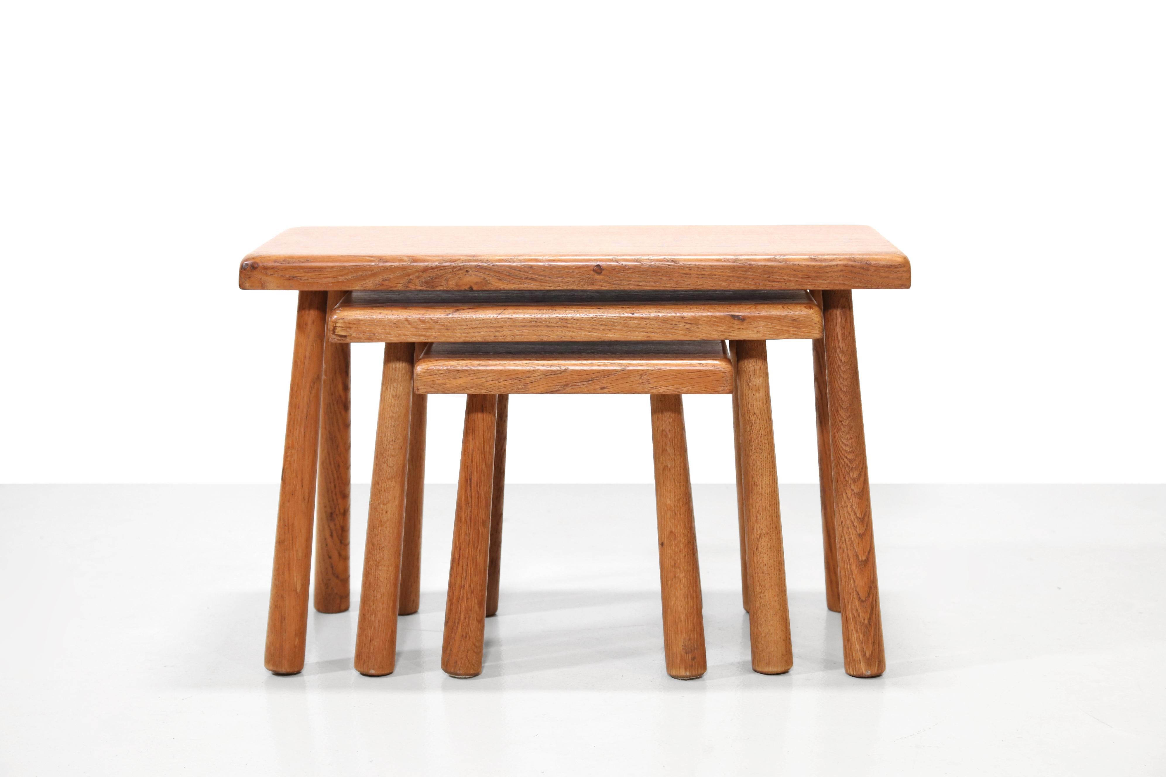 Beautiful set of three solid oak tables. This brutalist set can be conveniently pushed under each other so that they do not take up too much space. They can also be placed separately in the room. The largest table can also function as a bench. The