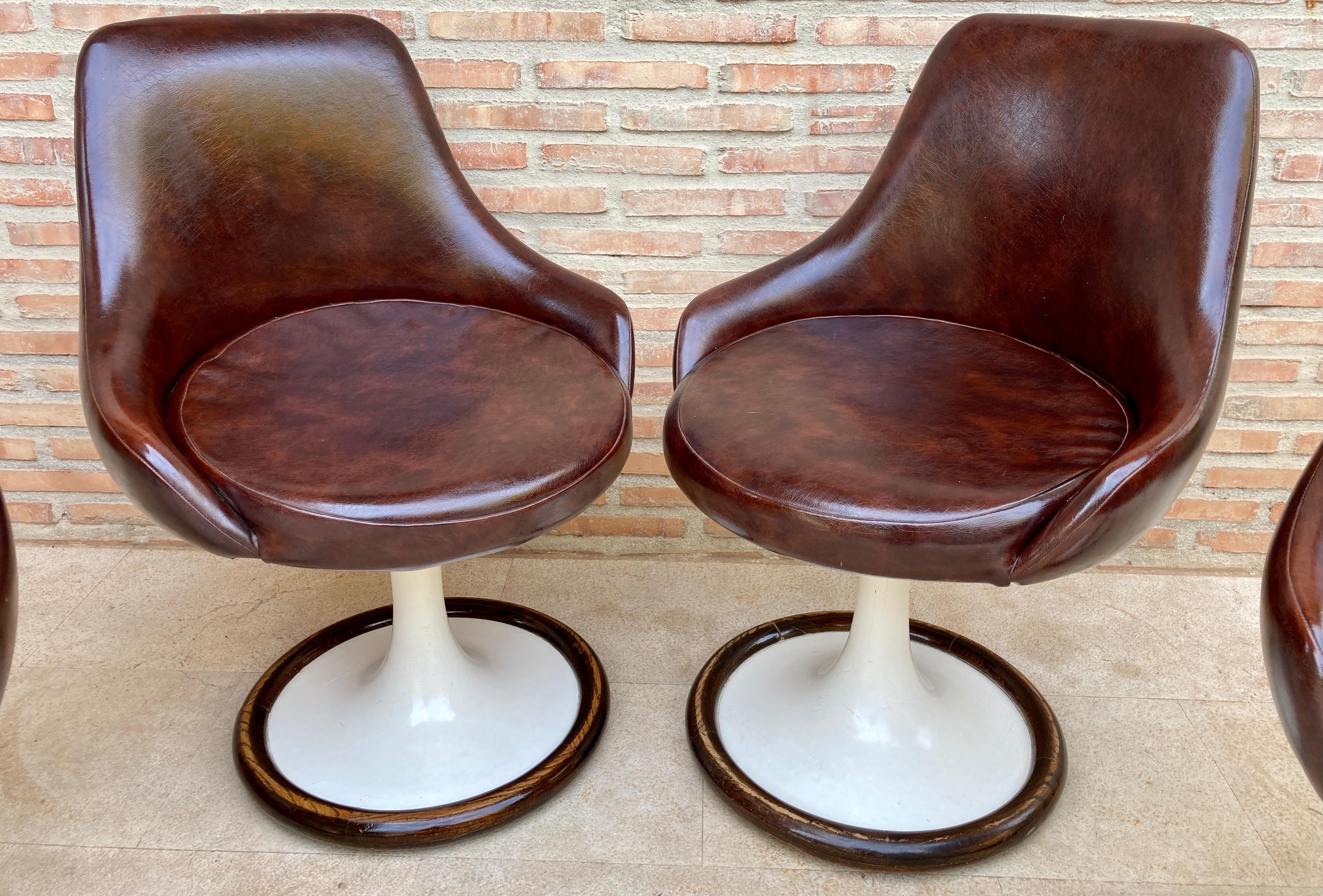 Impressive set of original chairs are made of white plastic and wood base. The seat is upholstered in original brown leather. In good shape. 
Chairs and bases in good condition with only minor marks, consistent with age. Leather is good too.