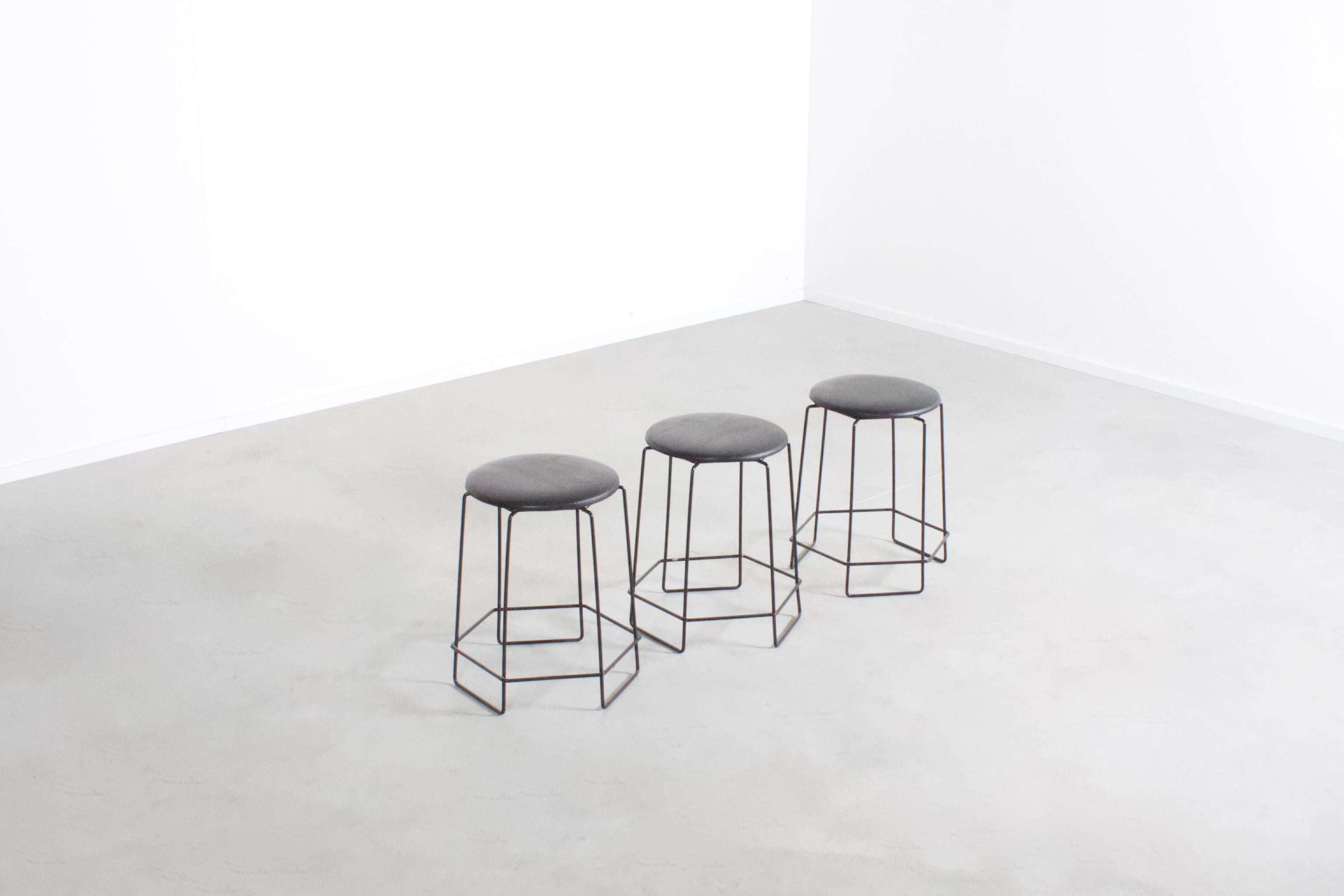 Set of wire stools in very good condition. 

Black wire frame in the original lacquer. 

The seats are upholstered in a black faux leather. 

The stools can be stacked.

We offer a variety of insured shipping services, ask us for the possibilities