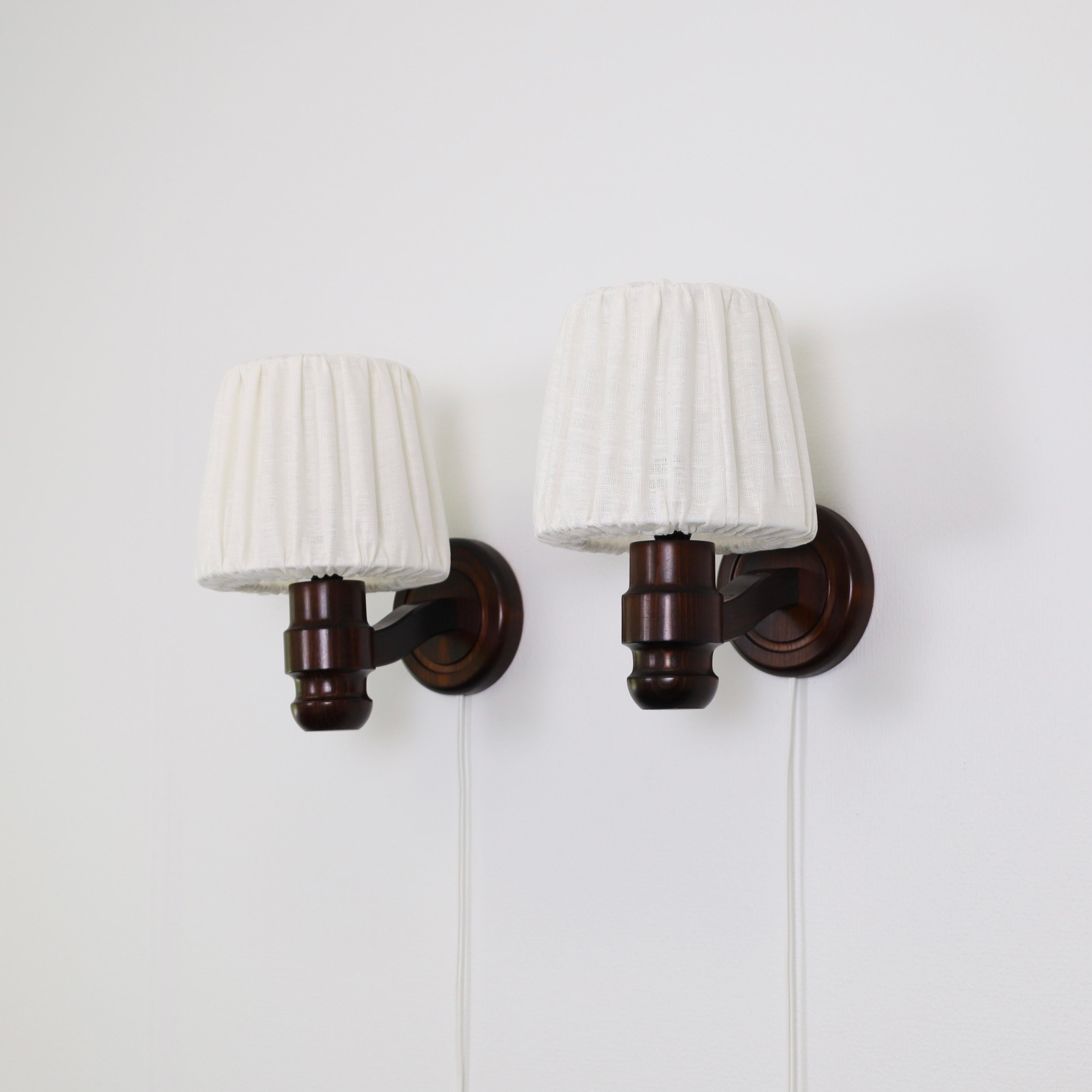 Un conjunto Lámparas de pared de madera de pino teñido de oscuro fabricadas por Solbackens Svarveri en la década de 1970. Un toque escandinavo para una casa preciosa.

* Un par (2) de apliques de madera de pino teñida de oscuro con las pantallas de