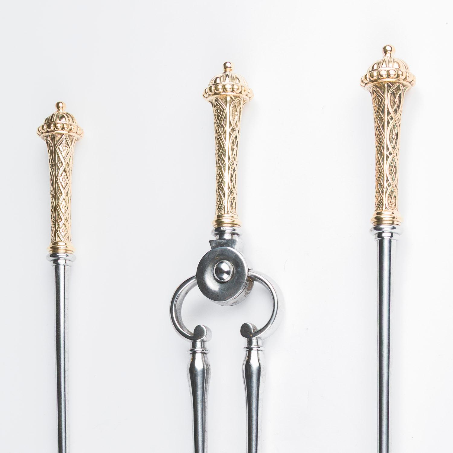 A set of three early 19th century steel fire irons, shovel, tongs, and poker, each with ornate brass handles with coronet finals and reticulated chased design.