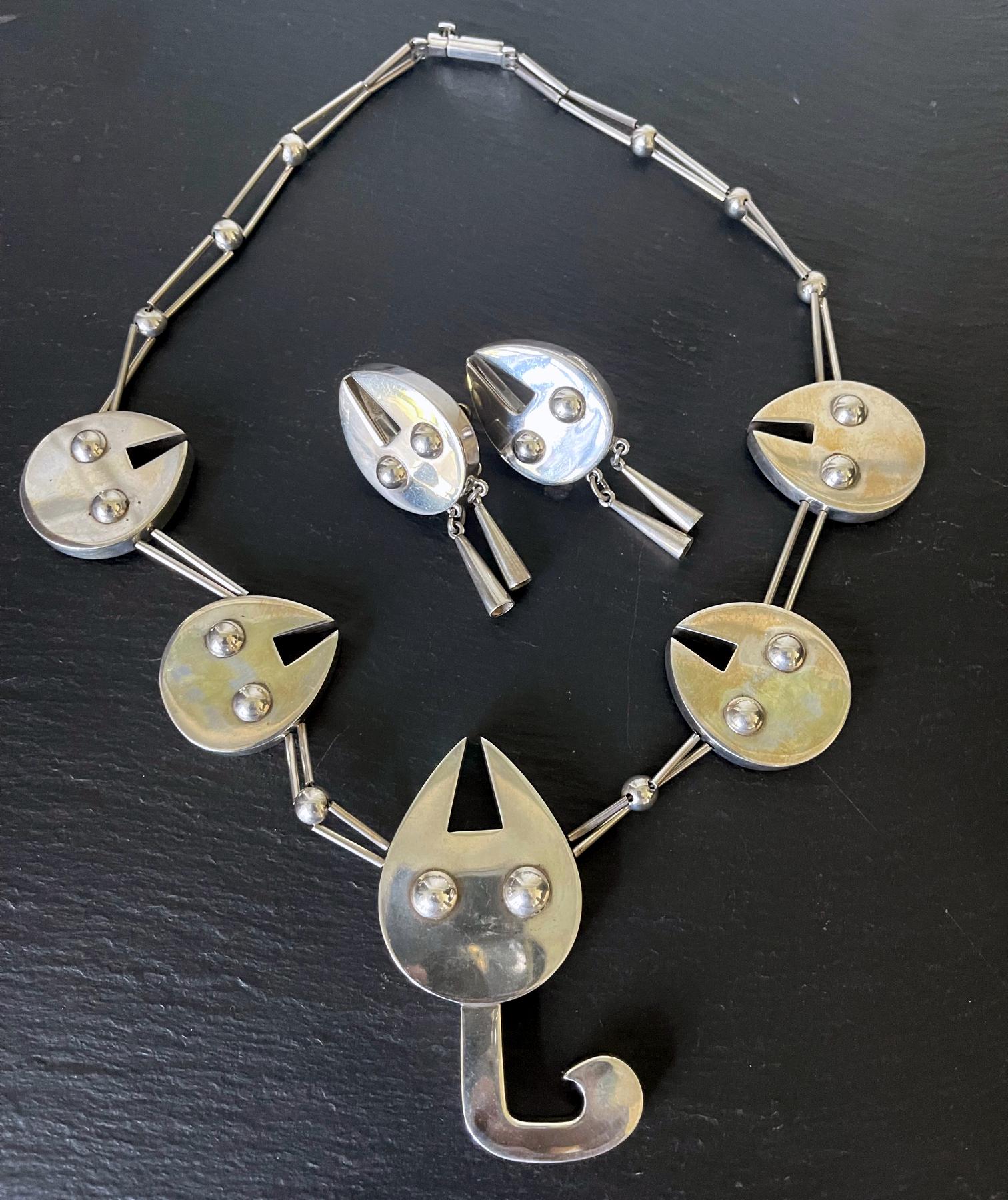 A three-piece sterling silver jewelry suite consisting of a necklace and a pair of earrings by Peruvian silversmith and designer Grazielle Laffi (1923-2009), Lima, circa 1970. Marks to necklace: PERU, 950. The main motif on the necklace and pedants