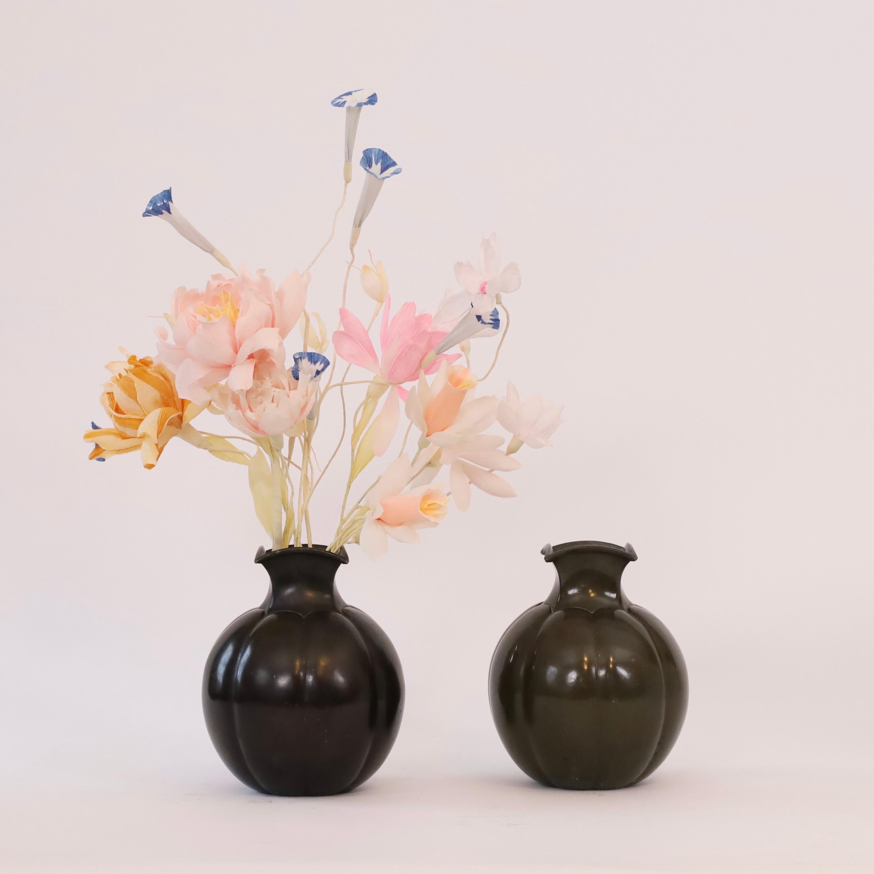 A set of substantial metal vases designed by Just Andersen in the 1930s. A rare, exquisite duo. 

* A set (2) of heavy round metal vases with square necks
* Designer: Just Andersen
* Model: D1754 (stamped 'Just D1754')
* Year: 1935
* Condition: Good