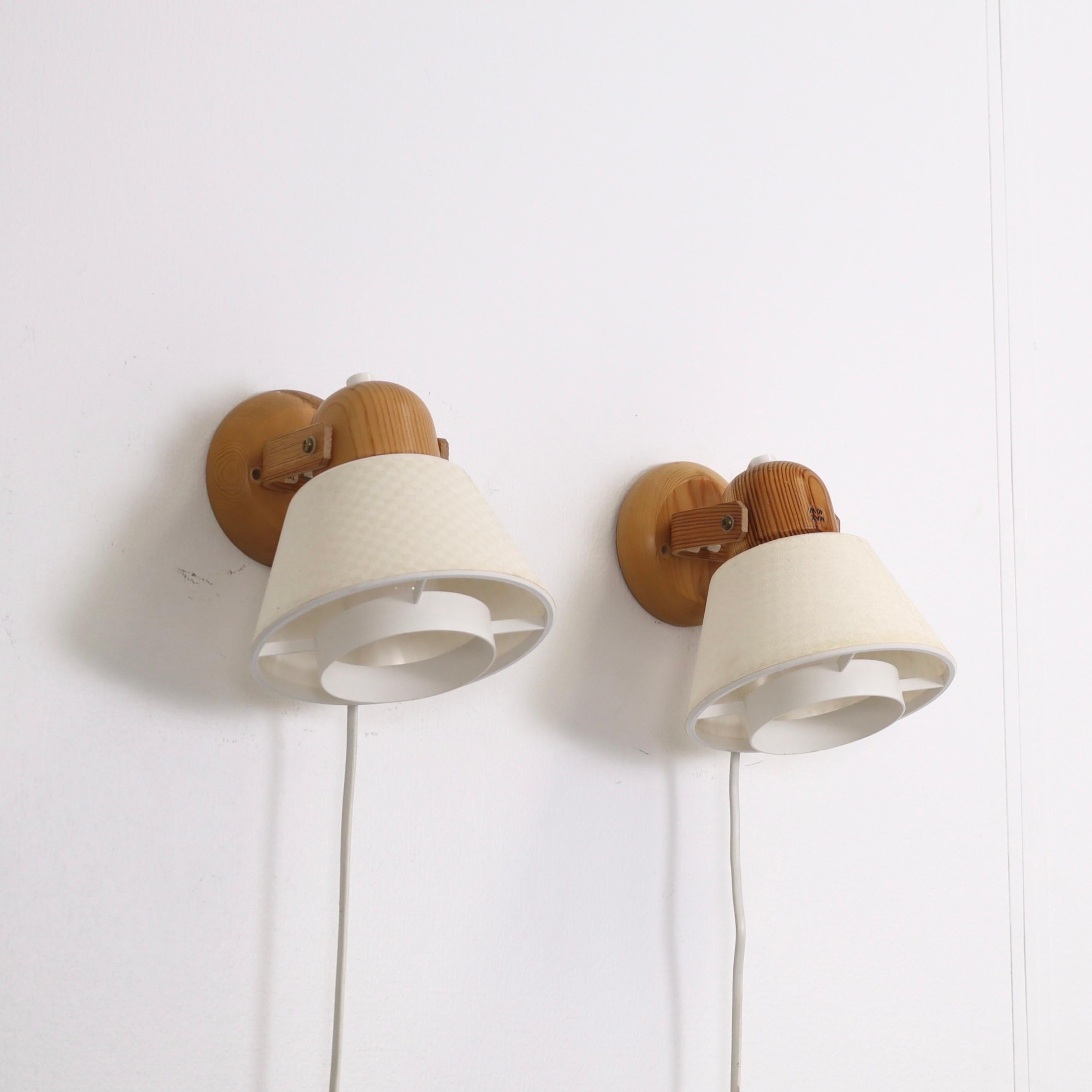 A set Swedish Modern Pine wood bed lamps made by Solbackens Svarveri in the 1970s. A Scandinavian touch for a beautiful home.

* A pair (2) of sconces in Pine wood with off-white fabric shades with checker prints.
* Manufacturer: Solbackens