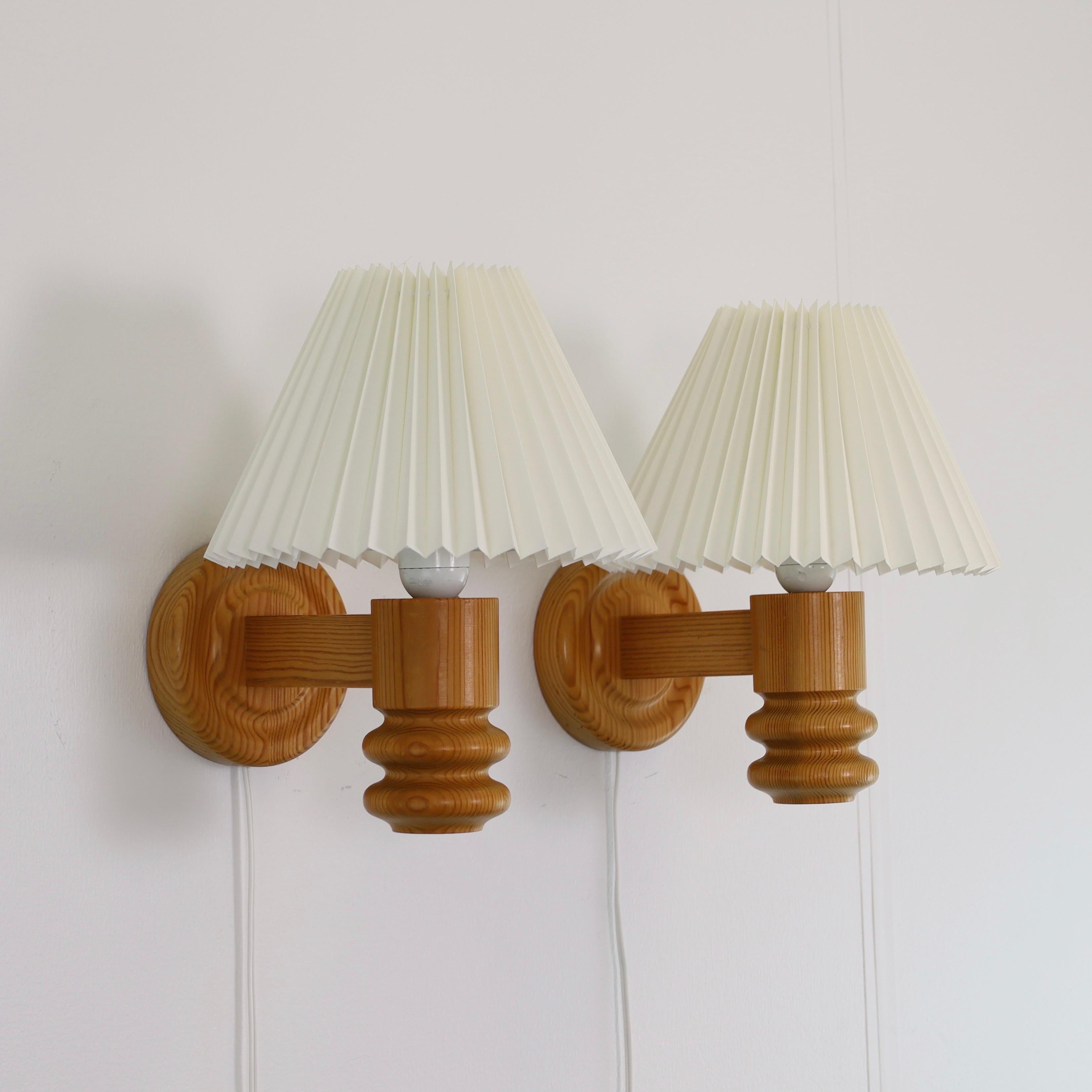A set Swedish Modern Pine wood Wall lamps made by Solbackens Svarveri in the 1970s. A Scandinavian touch to a beautiful home.

* A pair (2) of wall lamps in Pine wood with white pleated fabric shades.
* Manufacturer: Solbackens Svarveri, Sweden
*