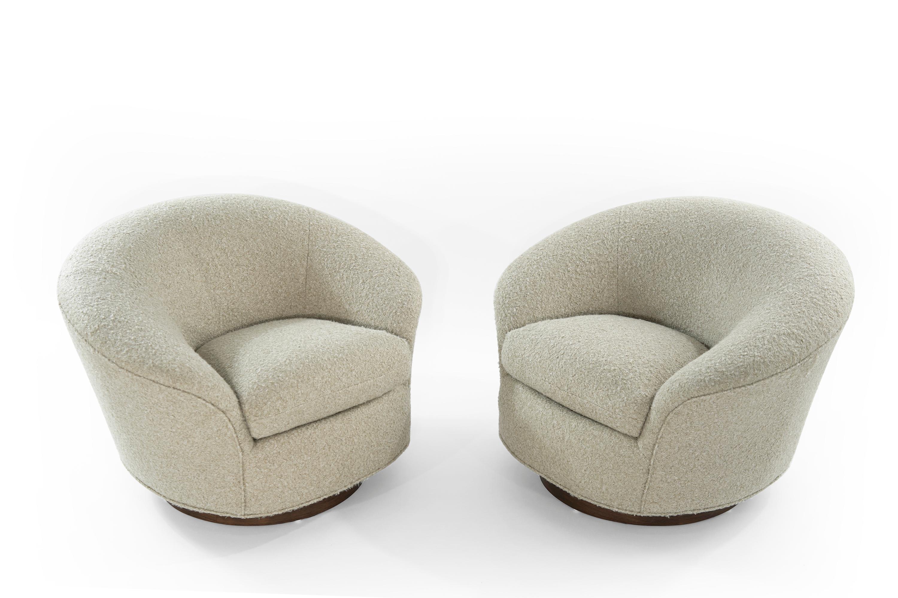 An extremely comfortable set of low and wide swivel / rock chairs by Directional. Newly upholstered in natural bouclé. Walnut support fully restored.