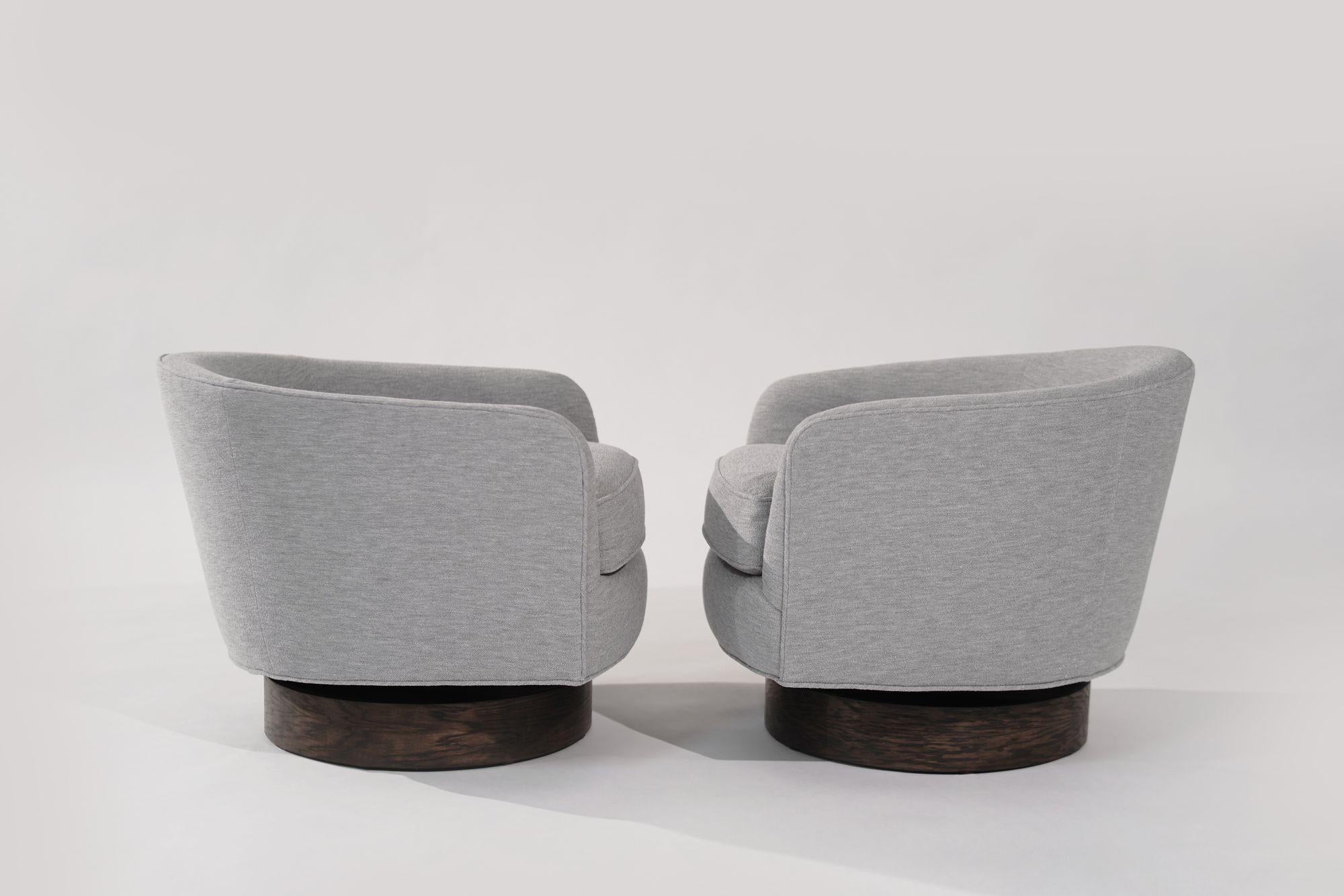 Step back in time with our vintage swivel tilt lounge chairs, circa 1960-1969, now reborn in chic grey bouclé upholstery. Fully restored oak swivel bases ensure durability and style. Experience the perfect fusion of mid-century charm and modern
