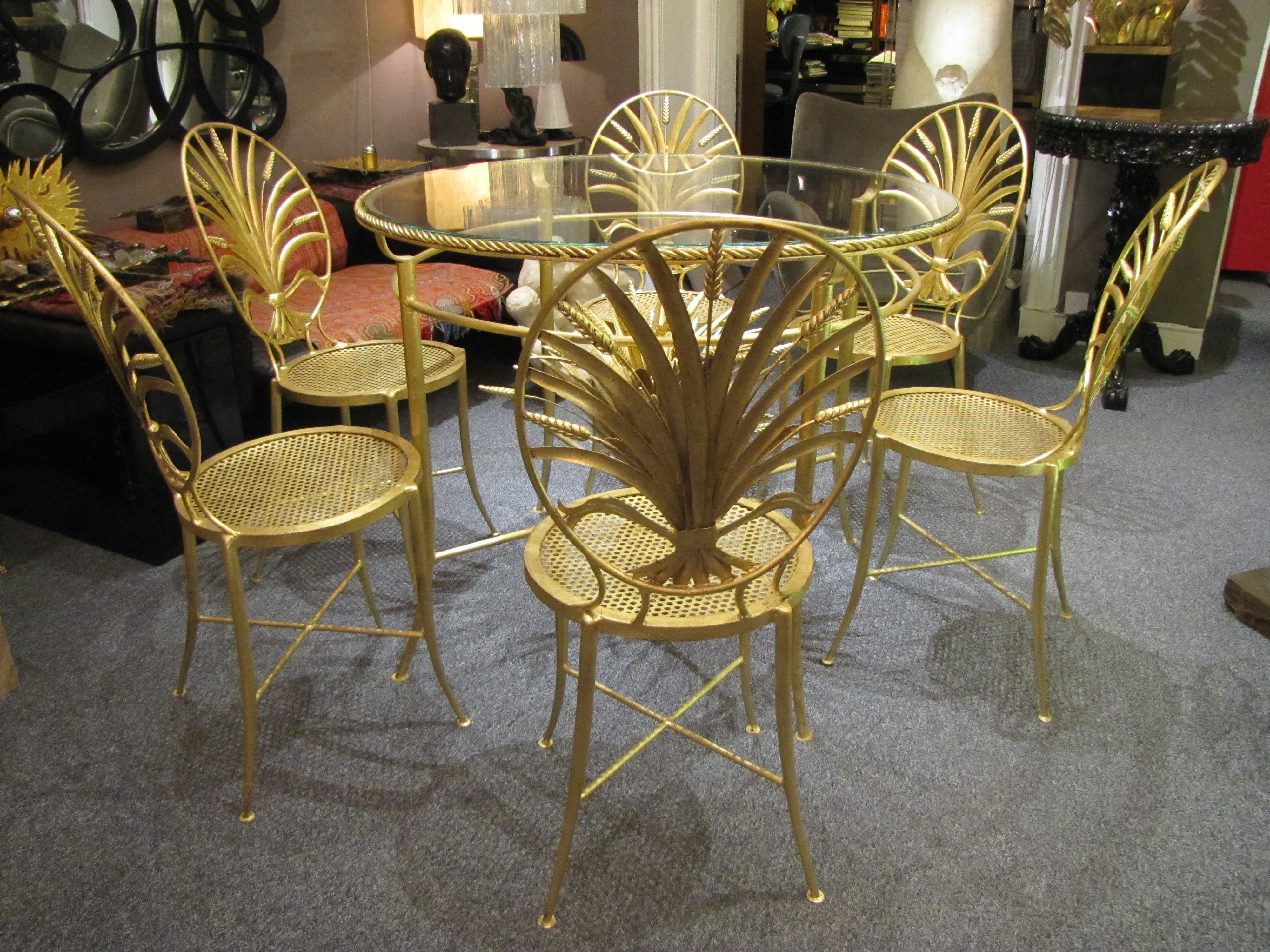 Rare ensemble de table et de six chaises italiennes des années 1960 avec des dossiers minutieusement détaillés, dans le design d'une gerbe de blé. Il repose sur de superbes pieds minces avec brancards en X, finition italienne classique en or doré.