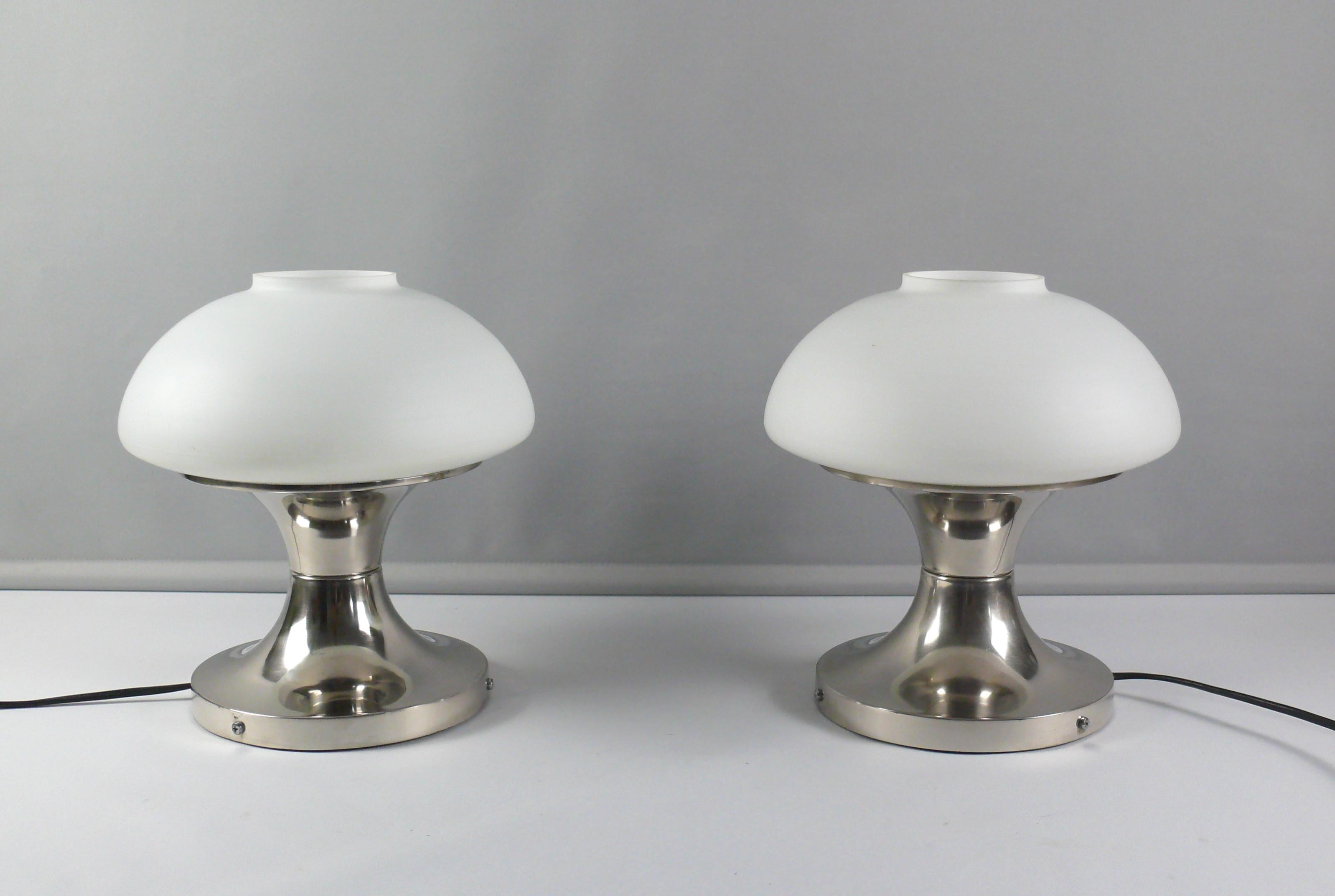 Two rare and elegant table lamps made of opal glass with a chrome-plated metal base made by VEB Leuchtenbau Leipzig, GDR - design classic of the Space Age era, 1976. The lamps impress with its unusual shape paired with solid workmanship. Both lamps