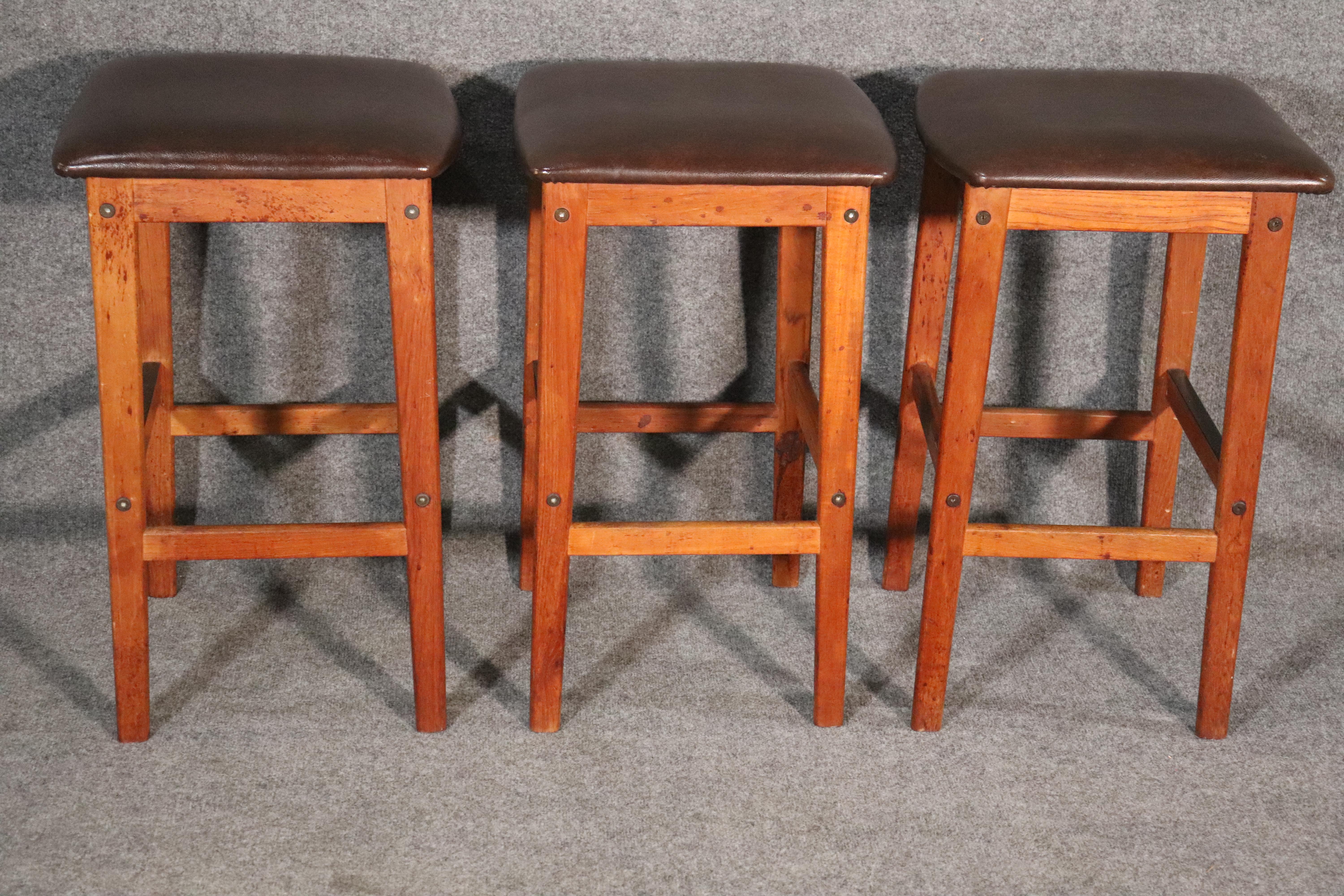 Set of three mid-century stools with teak frames and leather style cushions. Counter height with footrests.
Please confirm location NY or NJ