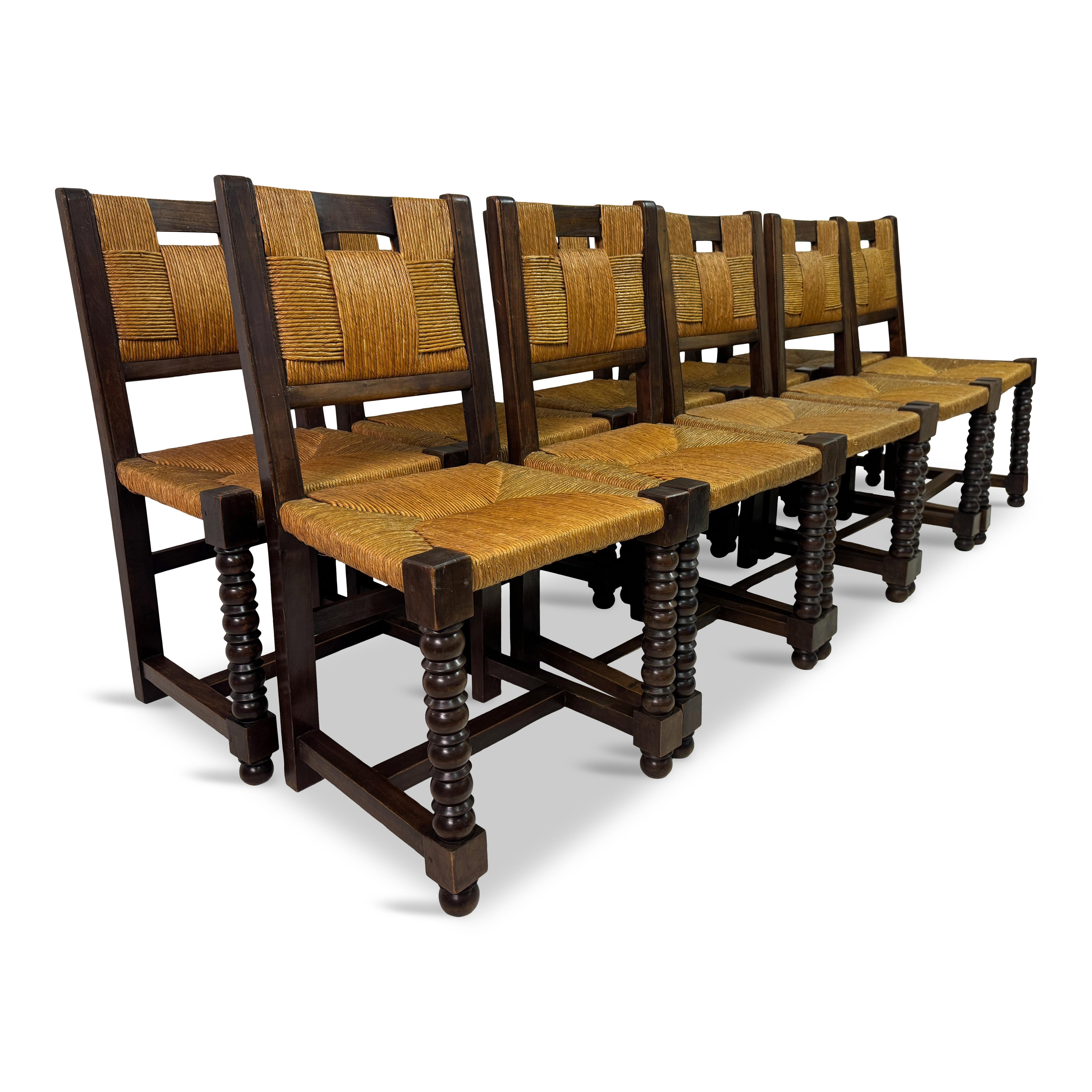 Set of ten dining chairs

Oak frame

Rush seats and back

1940s France

We currently have another set of six of these chairs.

These are a set of ten French 1940s oak and rush chairs, crafted in the style of Charles Dudouyt and Victor Courtra. The