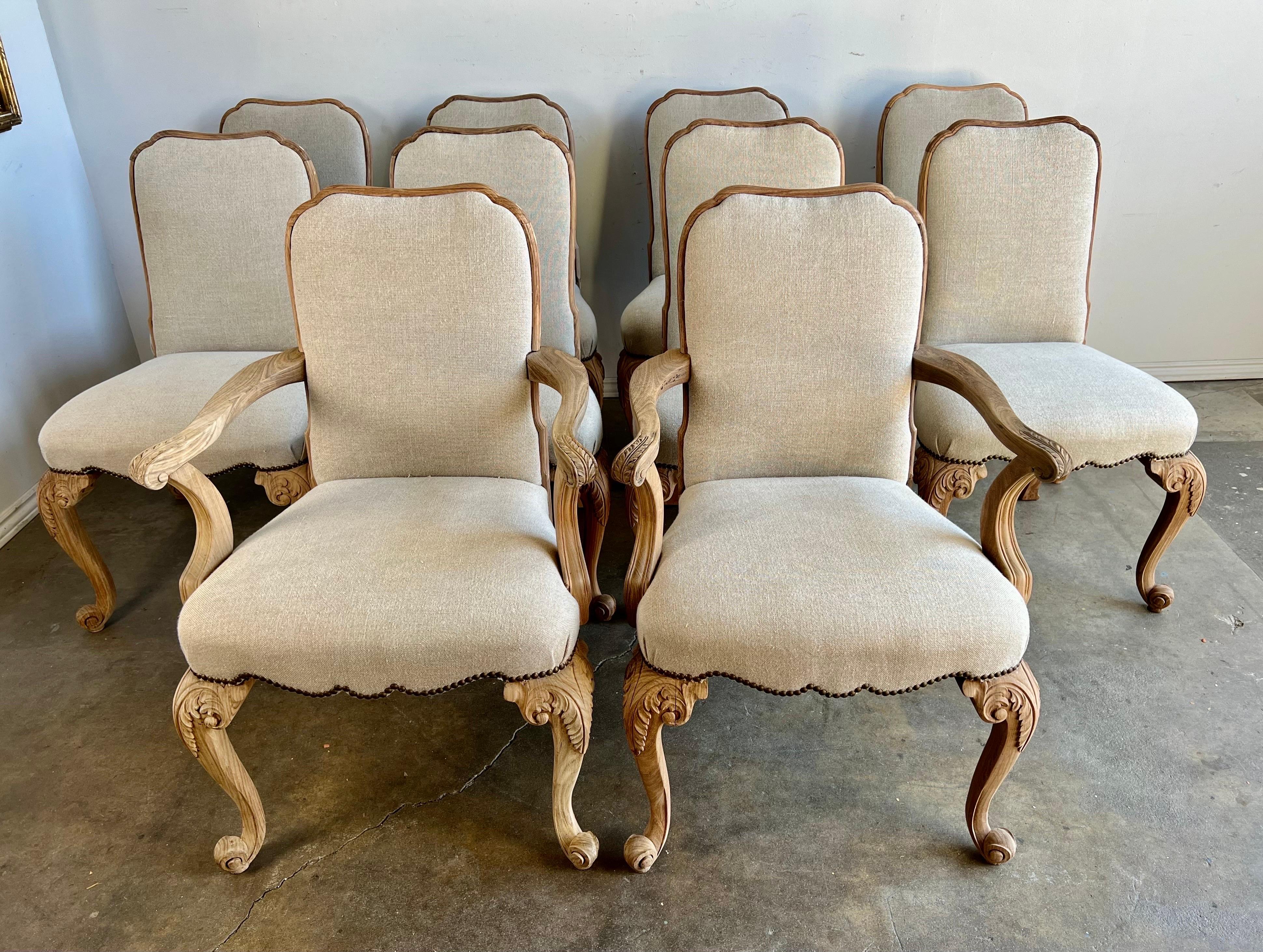Set of 10 19th C. French carved dining chairs beautifully carved and newly upholstered in washed Belgium linen. The chairs stand on four cabriole legs that end in rams head feet. We have the matching dining table sold separately.