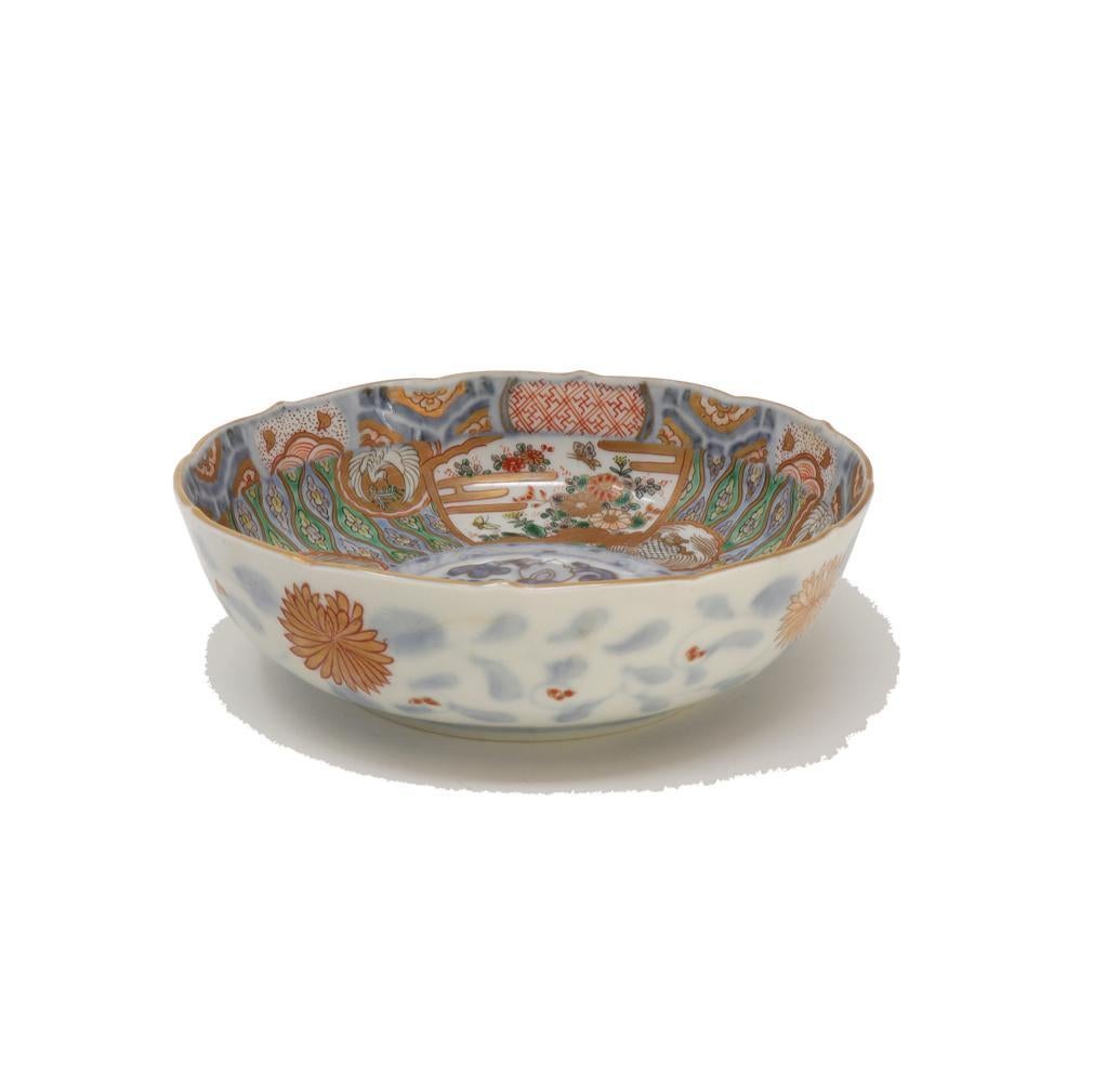  Ensemble de dix bols peu profonds anciens en porcelaine japonaise Imari. Cet ensemble de porcelaine fine est décoré en trois cuissons. La première cuisson en bleu de cobalt sous glaçure claire et foncée d'un médaillon floral à trois segments au