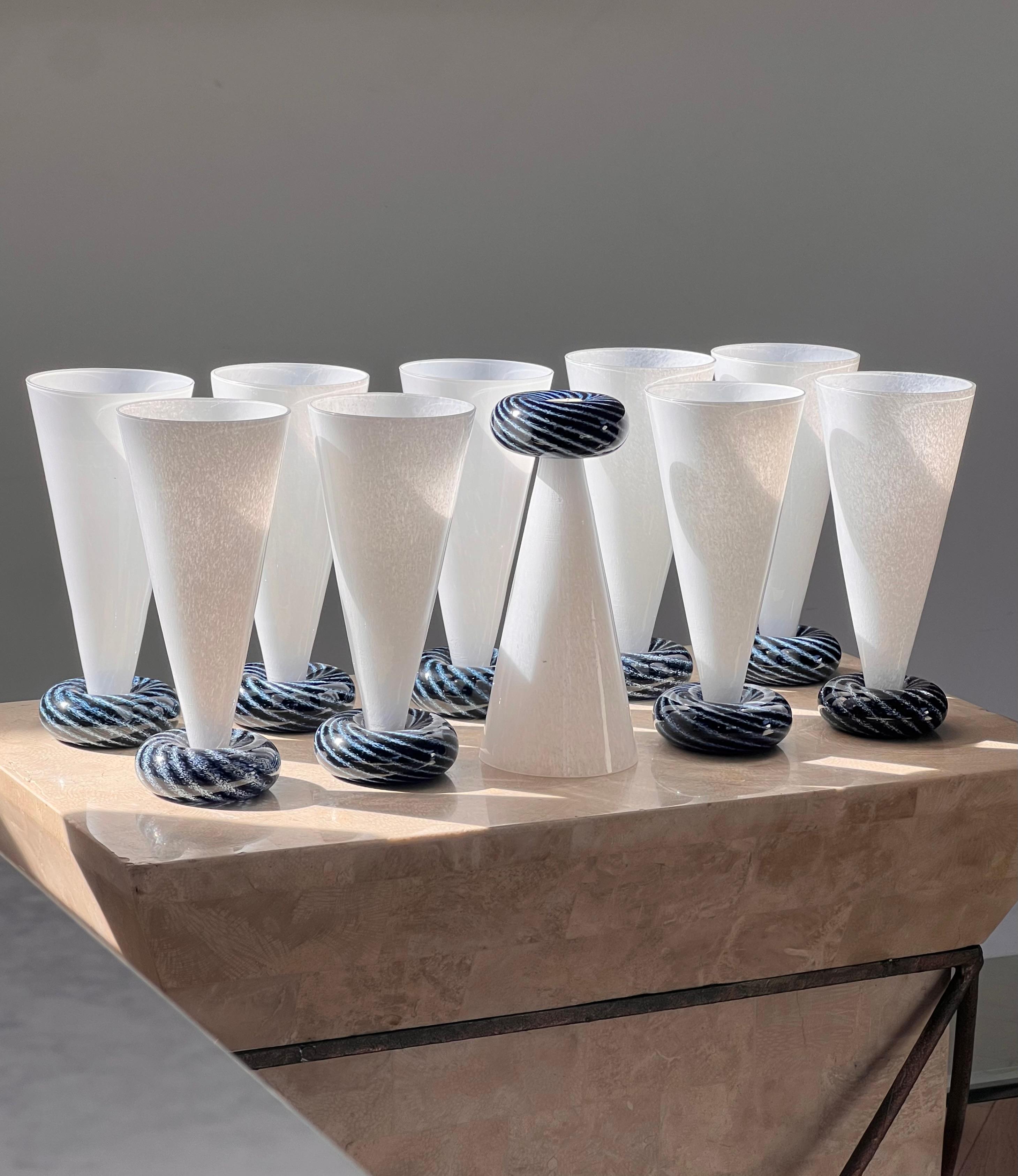A stunning vintage set of ten postmodern art glass champagne flutes designed by R. Guy Corrie for Union Glass, late20th century. These could also be used as tumblers - have it your way. With original maker’ mark sticker on verso. Each glass features