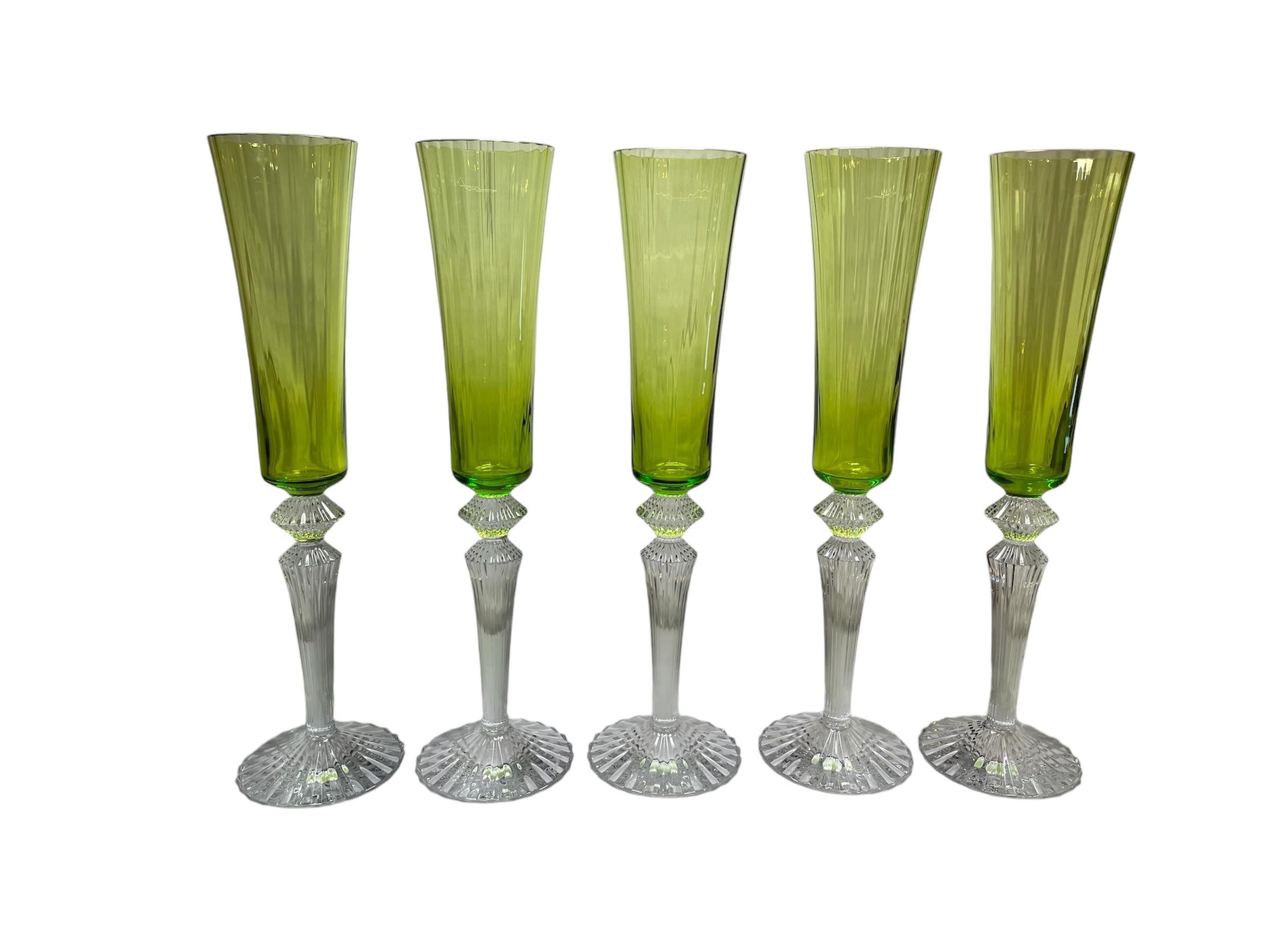 Este es un juego de diez flautas Baccarat Mille Nuits Flutissimo. Representa diez cuencos alargados estriados de color musgo, de cristal de champán, con pies y tallos estriados de cristal transparente. Las bases puntiagudas tienen forma de diamante.