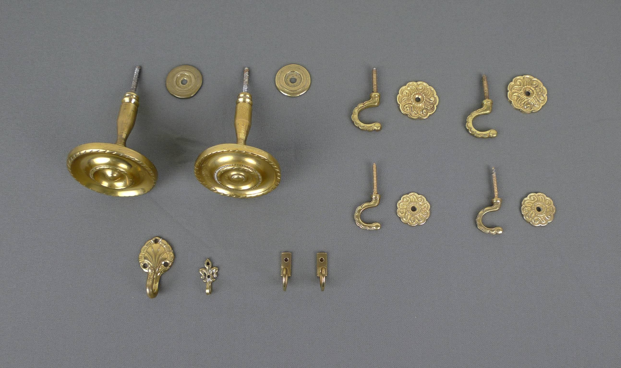 This set consists of ten different brass hooks in different sizes for wall mounting. They were produced in the 1950s in Germany.

Dimensions of the single hooks (not including threads) are:
- Two large tieback window hooks: 7,5 cm diameter x 9 cm