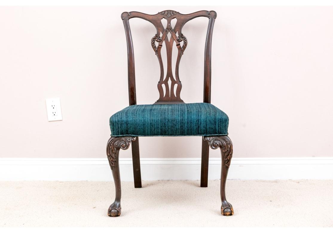 A set of ten Chippendale style dining chairs including eight side chairs and two armchairs. Beautifully crafted with warm-toned, dark brown frames sporting serpentine top rails and shapely openwork fiddle splats. Seats are upholstered in heathered