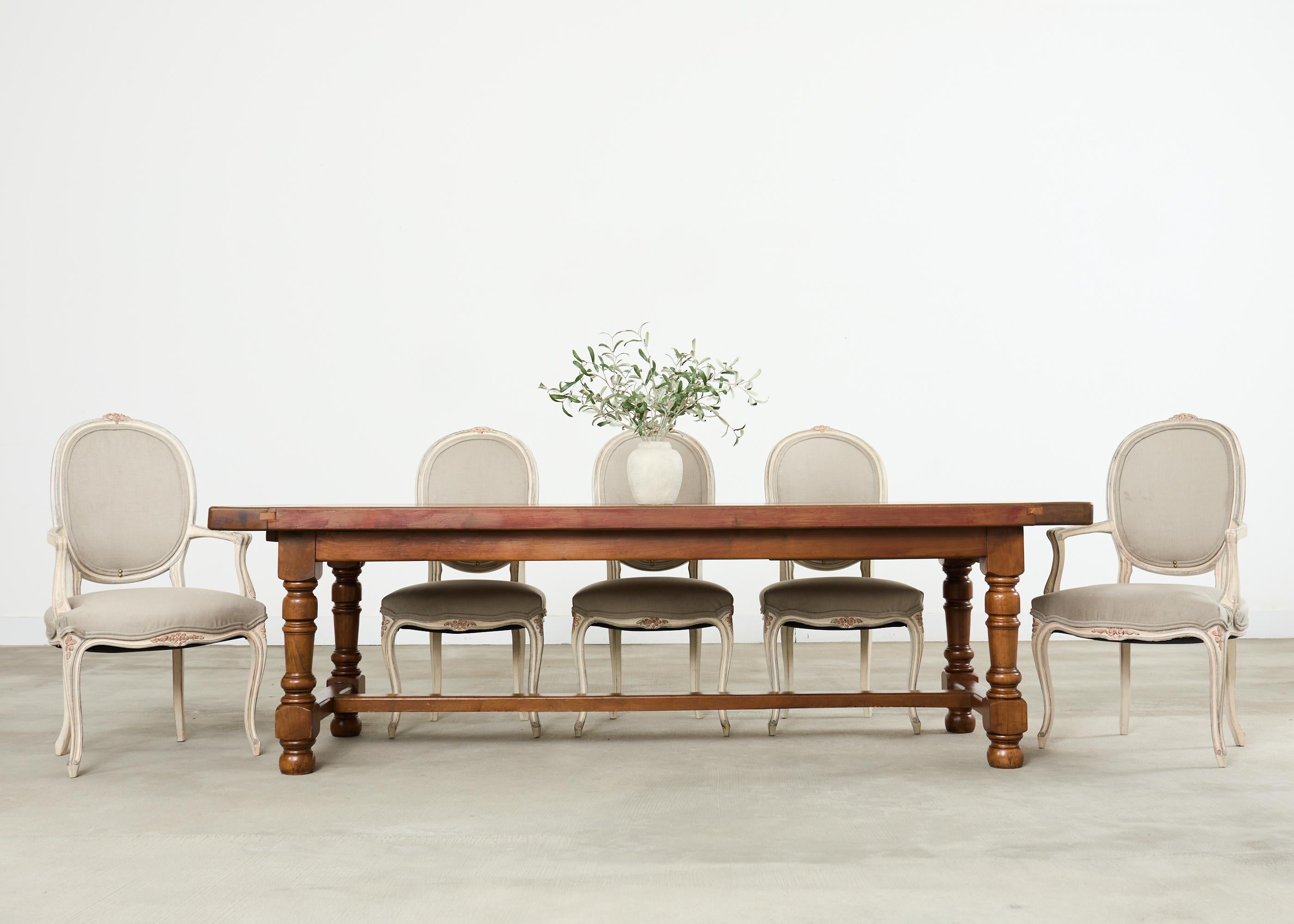 Sublime set of ten painted French dining chairs made in the country French provincial or Louis XV taste. The set consists of eight side chairs and two host fauteuil armchairs measuring 24 wide and by 23 deep and 41.5 inches high having 27 inch high