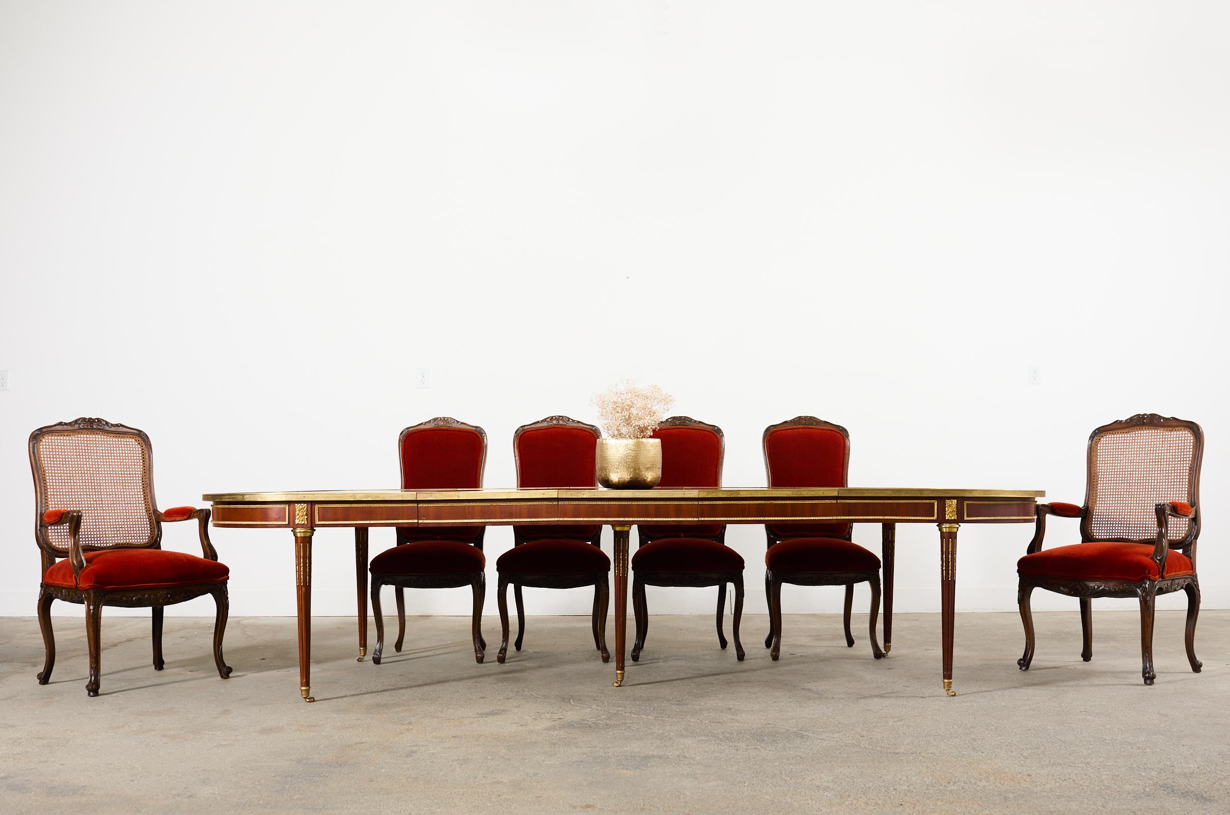 Grand set of ten carved walnut dining chairs crafted in the country French provincial or Louis XV taste. The set is comprised of eight side chairs and two host fauteuils armchairs with caned backs. The host fauteuils measure 24 wide and 41.5 inches