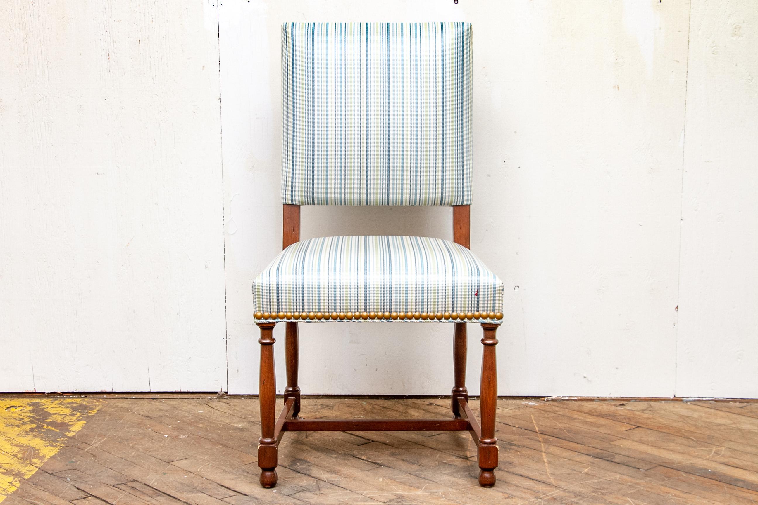 Two arm and eight side chairs. Mahogany frames with turned legs and H stretchers. Upholstered in a laminated blue and white stripe with contrast blue backs and full surround nail-head trim.

Condition: Good condition with expected signs of use