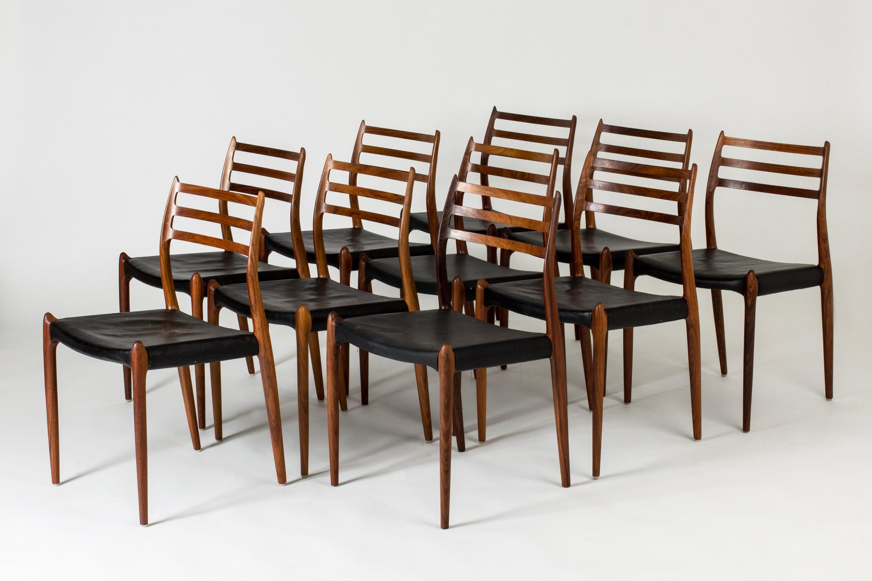 Set of ten gorgeous rosewood dining chairs by Niels O. Møller. Vintage black leather seats. The fluency of the design and the hornlike details at the seats and on the backrests give these chairs a breathtaking grace with daring undertones.