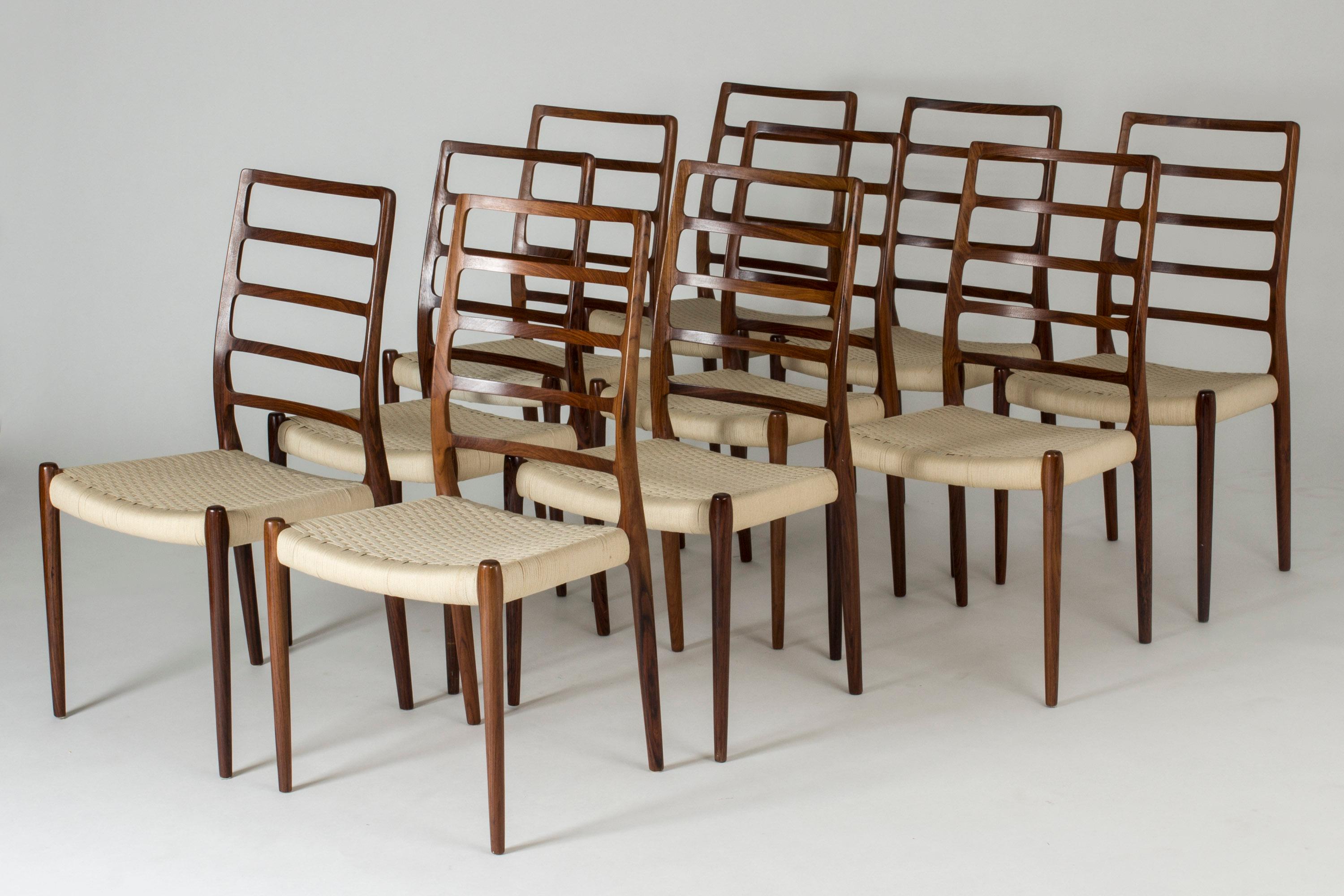 Set of ten amazing dining chairs by Niels O. Møller. Made from rosewood that is beautifully sculpted with seamless joinery. The woodgrain follows the lines of tall backrests. Wreathed cotton seats.