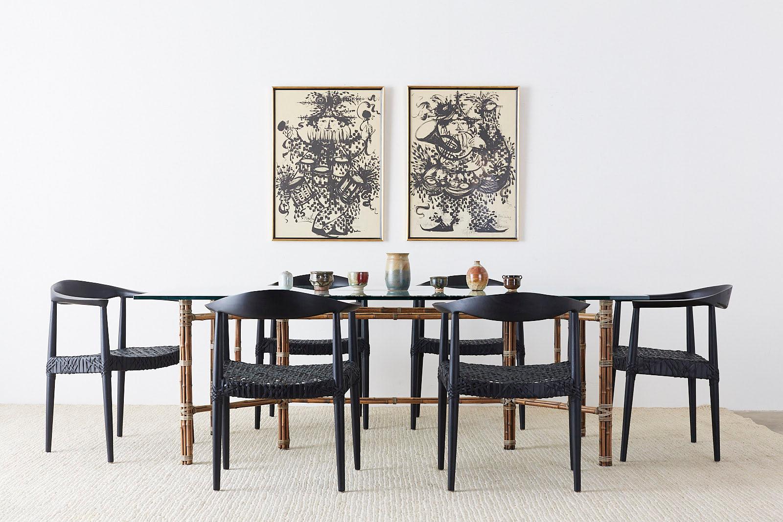 Dramatic set of 10 teak round chairs after Hans Wegner. Features an ebonized wood frame with leather strapping. Comfortable, reproduced after the chair made by Johannes Hansen designed by Hans Wegner in the Scandinavian modern style. Also known as