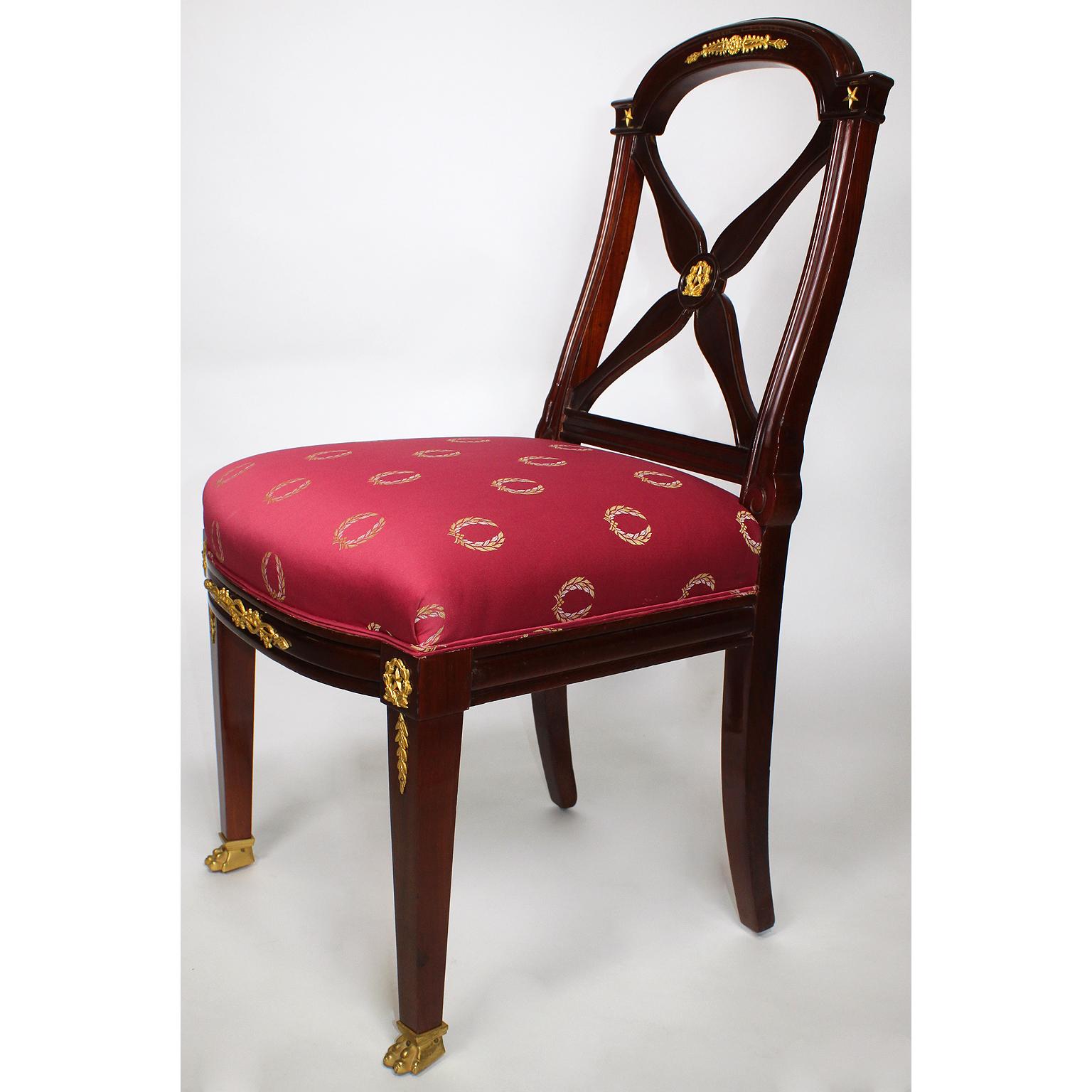 A fine set of ten 19th century French Empire Napoleon III mahogany and gilt bronze-mounted dining chairs by Jeanselme Pere & Fils. The slender mahogany frames with an arched cross-banded back, surmounted with gilt bronze mounts allegorical to the