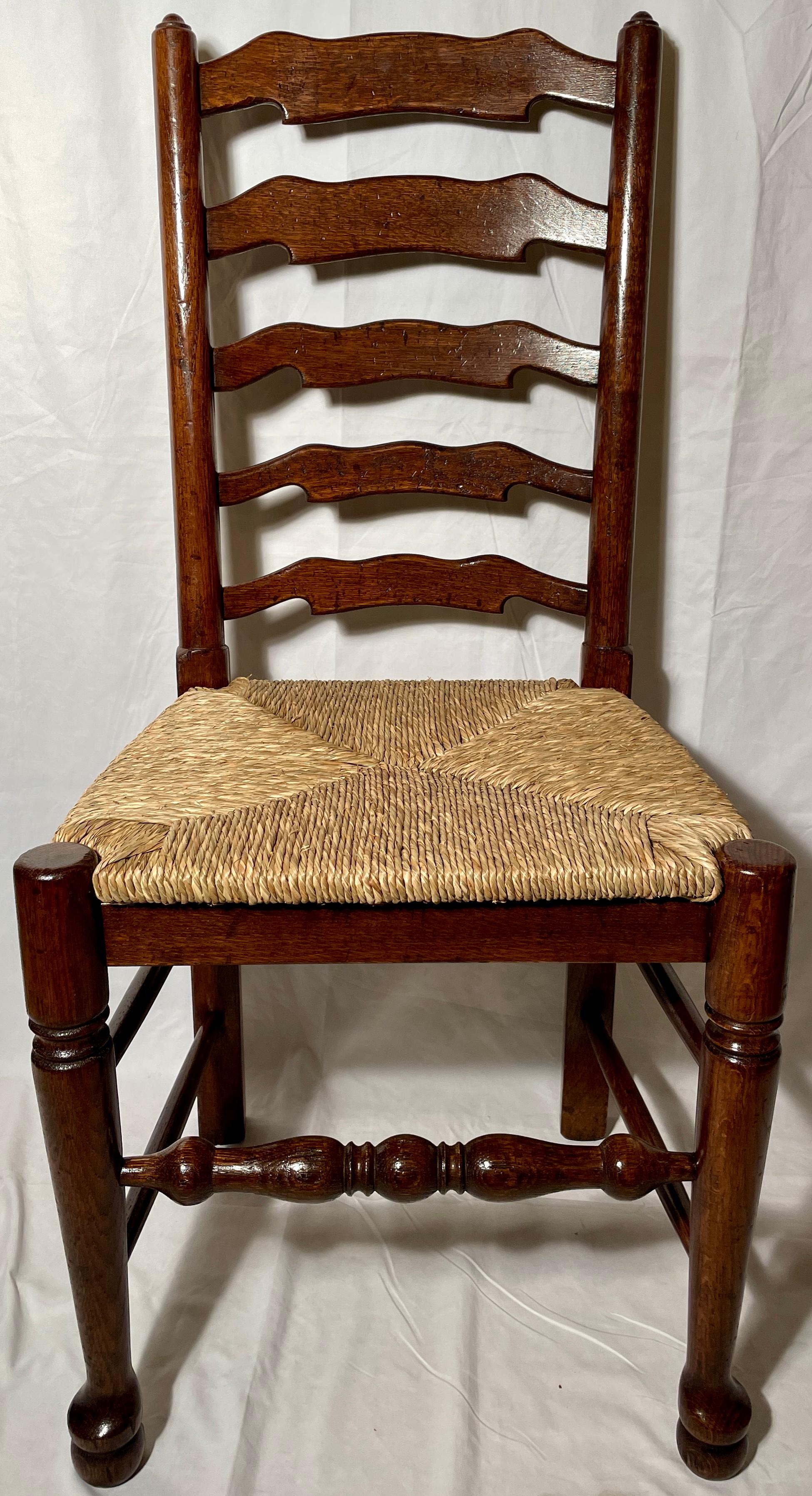 Set of ten English oak ladder back chairs with rush seats.