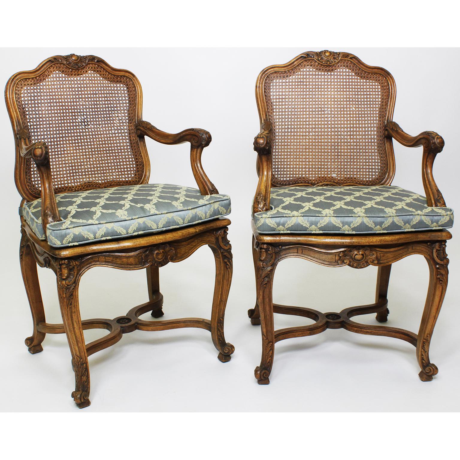 A fine assembled set of ten French 19th-20th century Louis XV Style Provincial carved walnut dining chairs. The finely carved frames comprising of eight chairs and two armchairs, all with cane backs and seats, fitted with removable upholstered