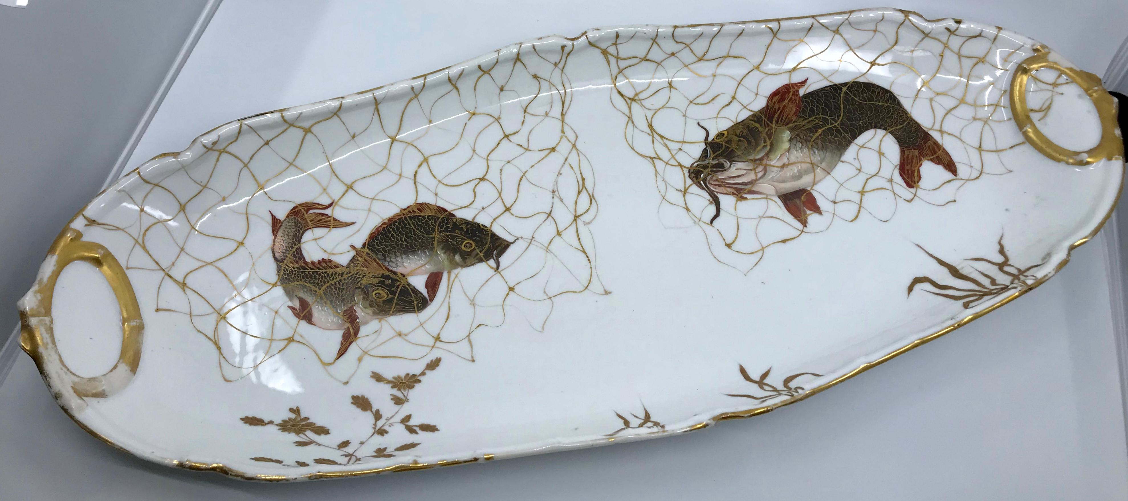 Set of ten Limoges French aesthetic movement fish plates and platter. Hand-painted and gilt Limoges porcelain fish service in a rare, modern Oriental-inspired design with five different pairs of fish in elegant fine gold nets and aquatic plants.