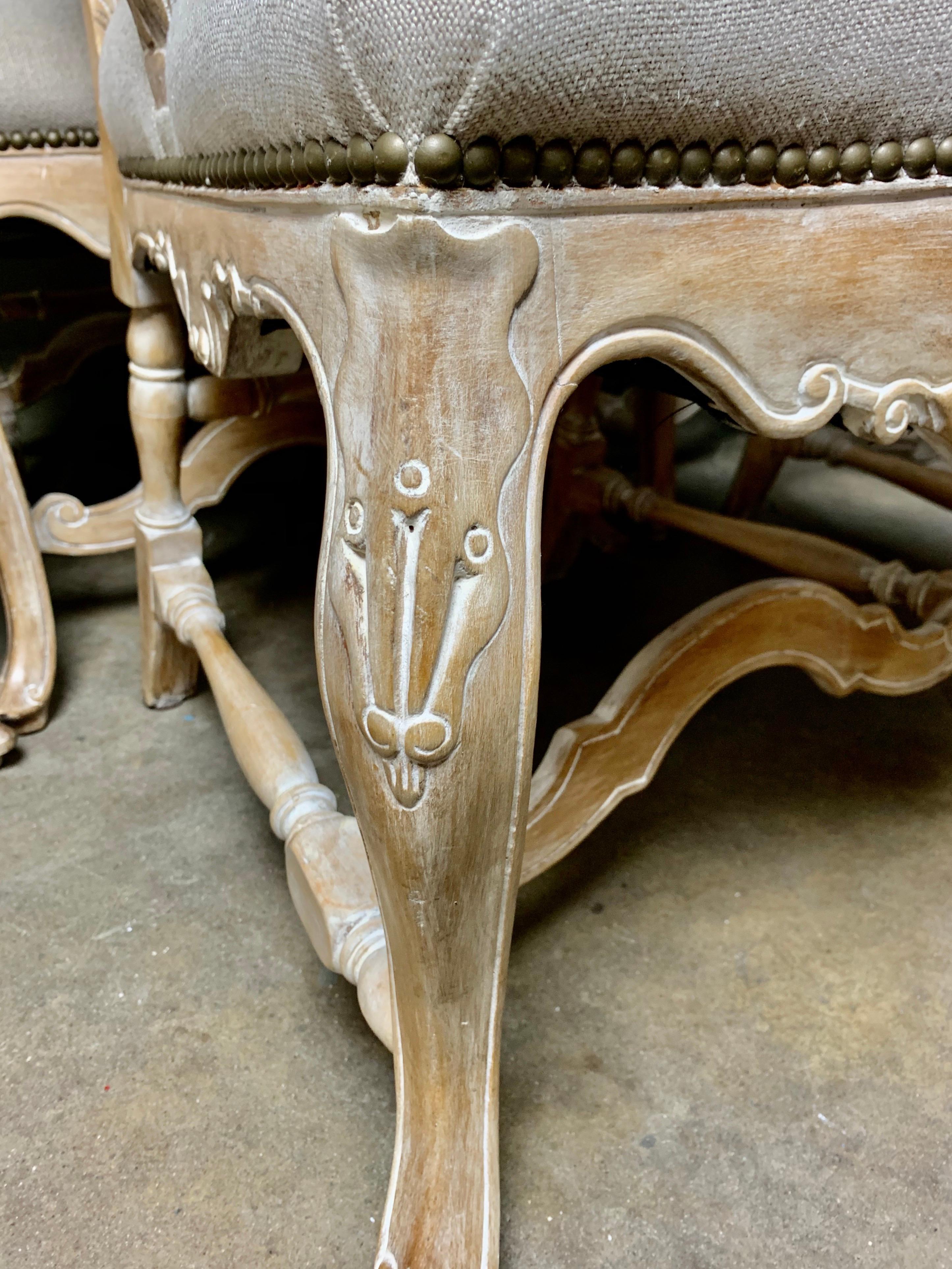 Set of Ten French Louis XV style dining chairs standing on cabriole legs that meet in a center stretcher. There is a beautiful shell motif on both the top and seat of the chair. The walnut dining chairs have been bleached into a beautiful soft