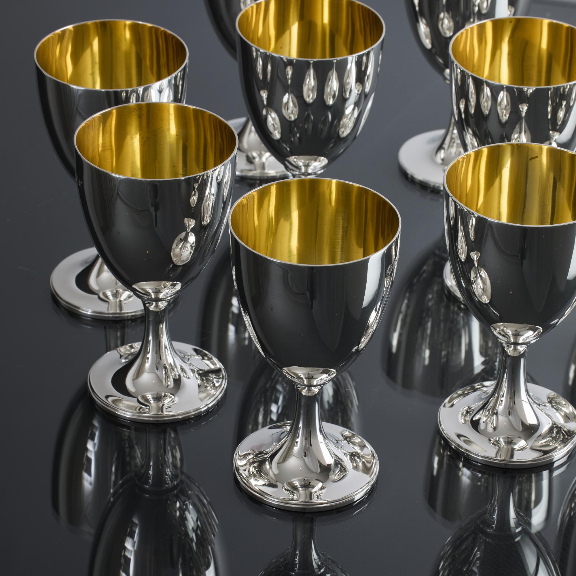 Set of eight 20th century silver goblets created in the George III style and featuring simple, plain round bodies on spreading circular bases. Each goblet's interior is nicely gilded, and the simplicity of these silver goblets lends them to being