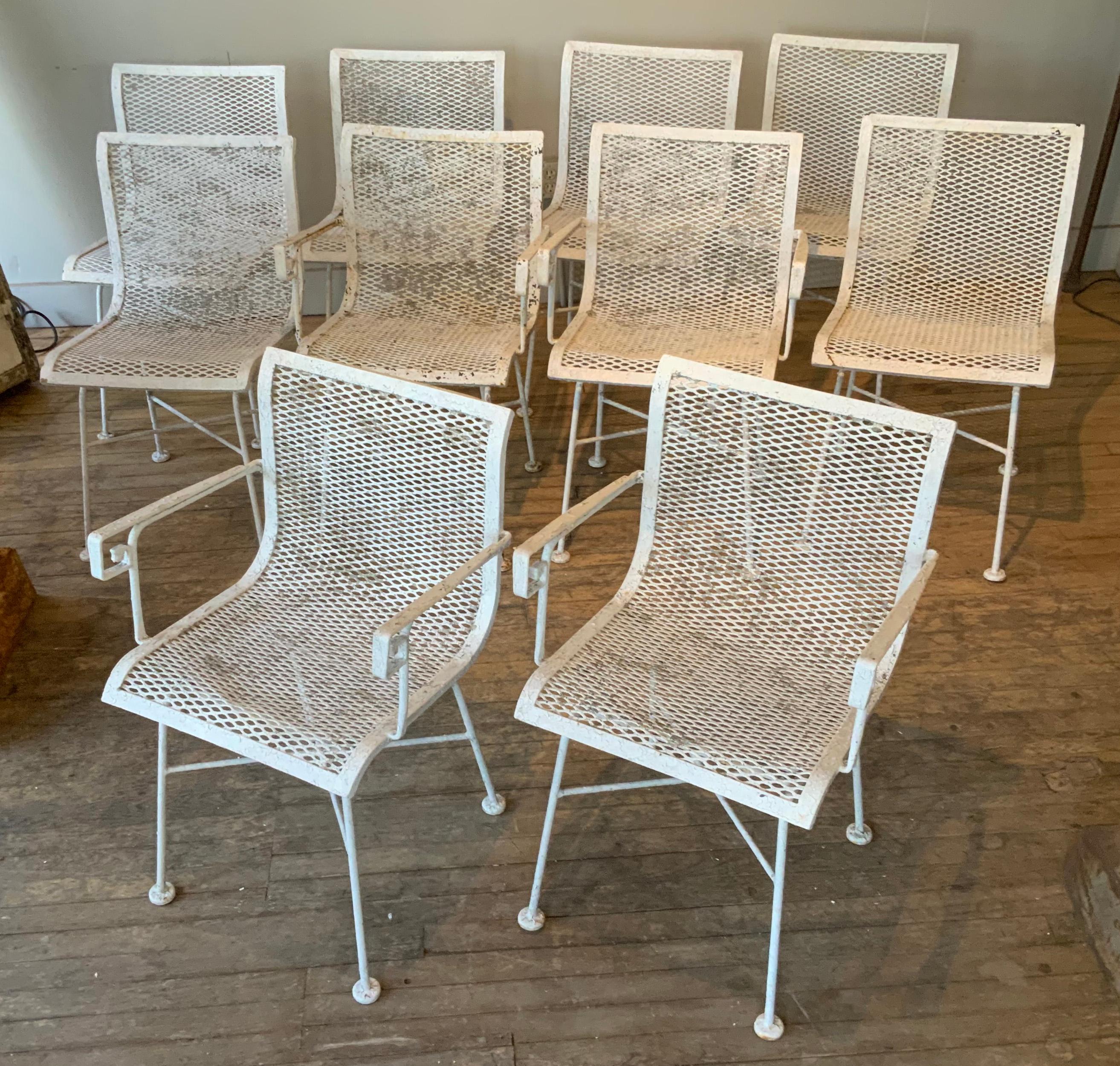 a large set of 10 wrought iron dining chairs, c. 1950, by Meadowcraft. the chairs are iron mesh, with subtle curved seats and backs, and a very nice Greek Key detail in the arm of the armchairs. the set includes 6 armless chairs and 4 armchairs.