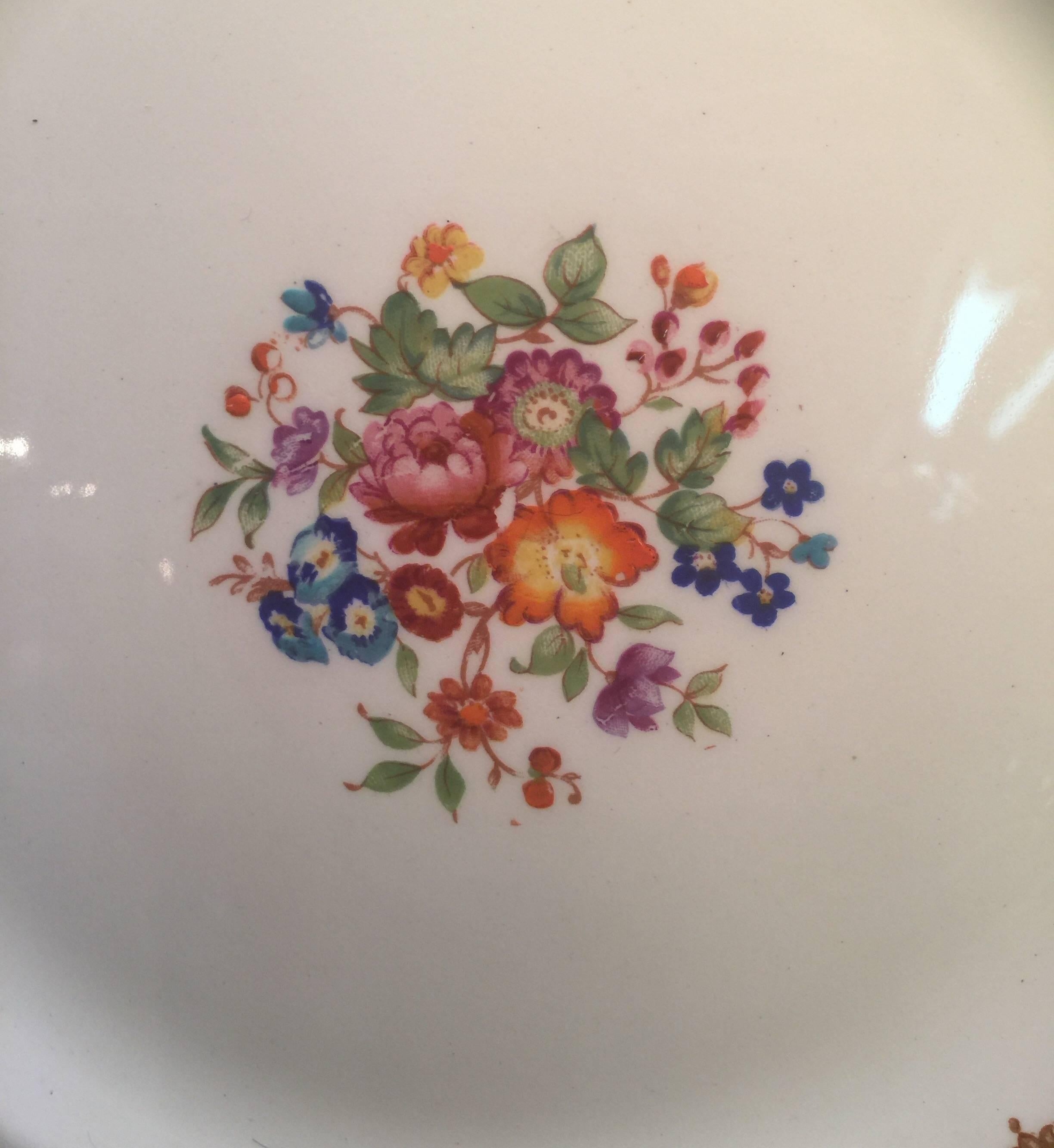 Vibrantly colored floral service plates with blue scaled borders and floral cartouches. Marked on the back, Alfred Meakin. Alfred Meakin Ltd was set up in 1875 and operated from the Royal Albert, Victoria and Highgate Potteries in Tunstall. Alfred