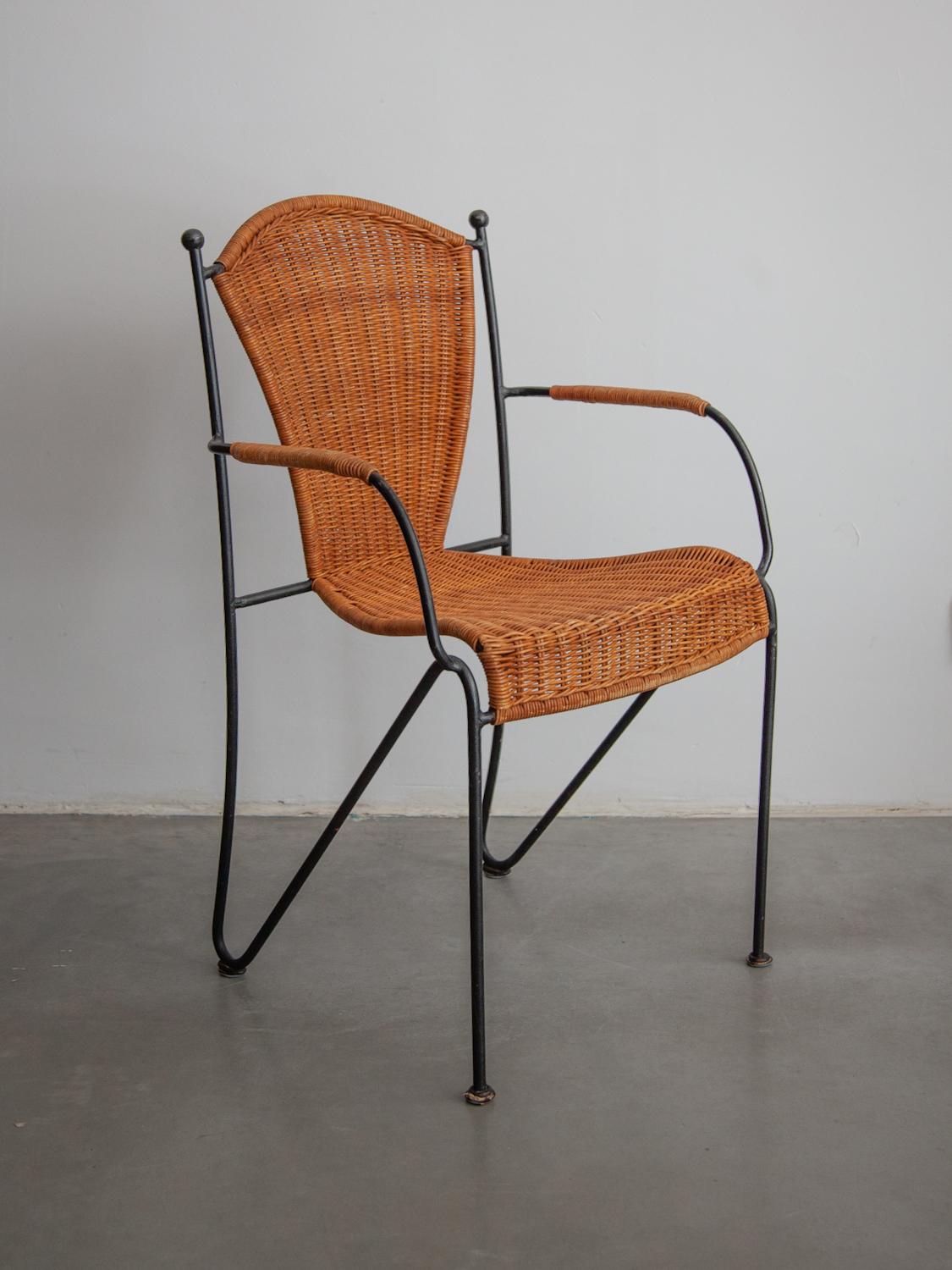 Vintage set indoor, outdoor dining chairs by designer Pipsan Saarinen Swanson for Ficks Reed.Sculptural black iron frames with gold ball ends. Woven rattan seats. Set of 10 chairs, two which have arm rests. 

Dimensions:No armrests: 44W x 85H x 44D