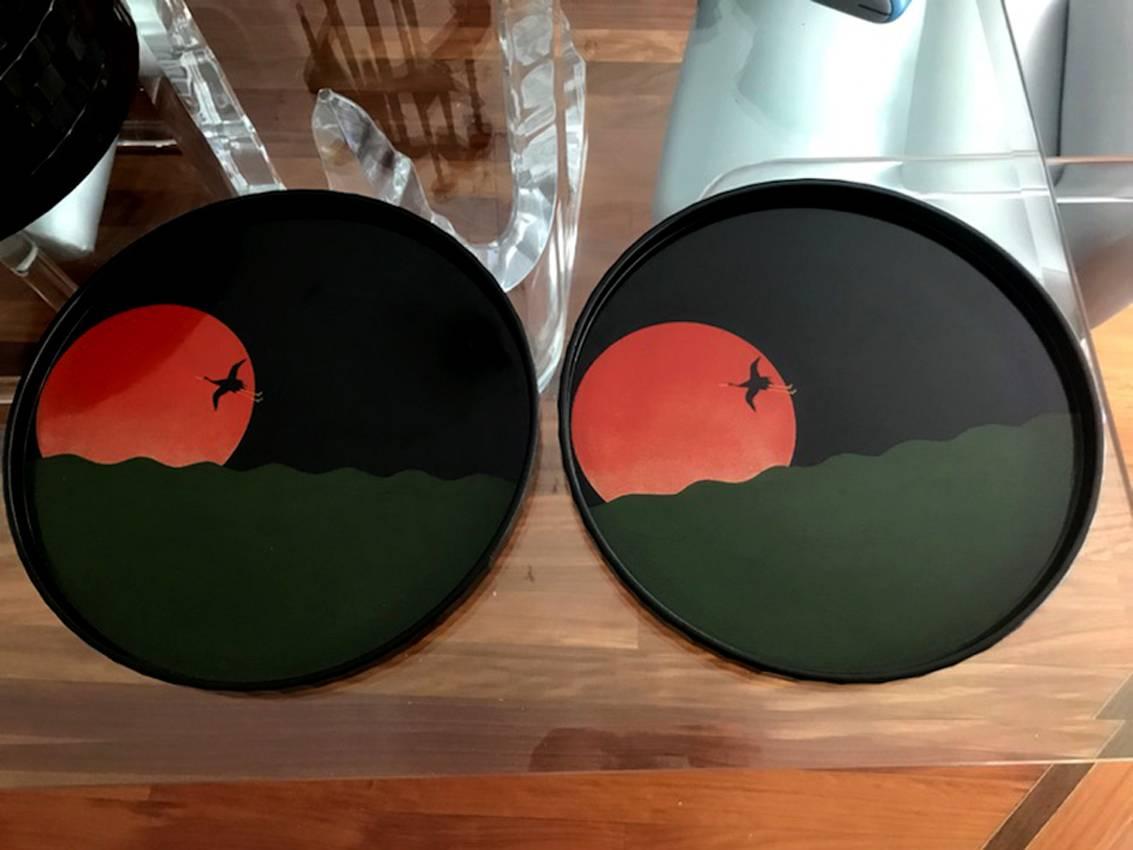 A set of ten lacquered trays from Japan, circa 1930-1940s. Decorated with crane flying over a setting sun on the waves, it was of high Japanese Art Deco fashion done in colored lacquer iro-urushi. Very subtle techniques of Maki-e and as an ornament
