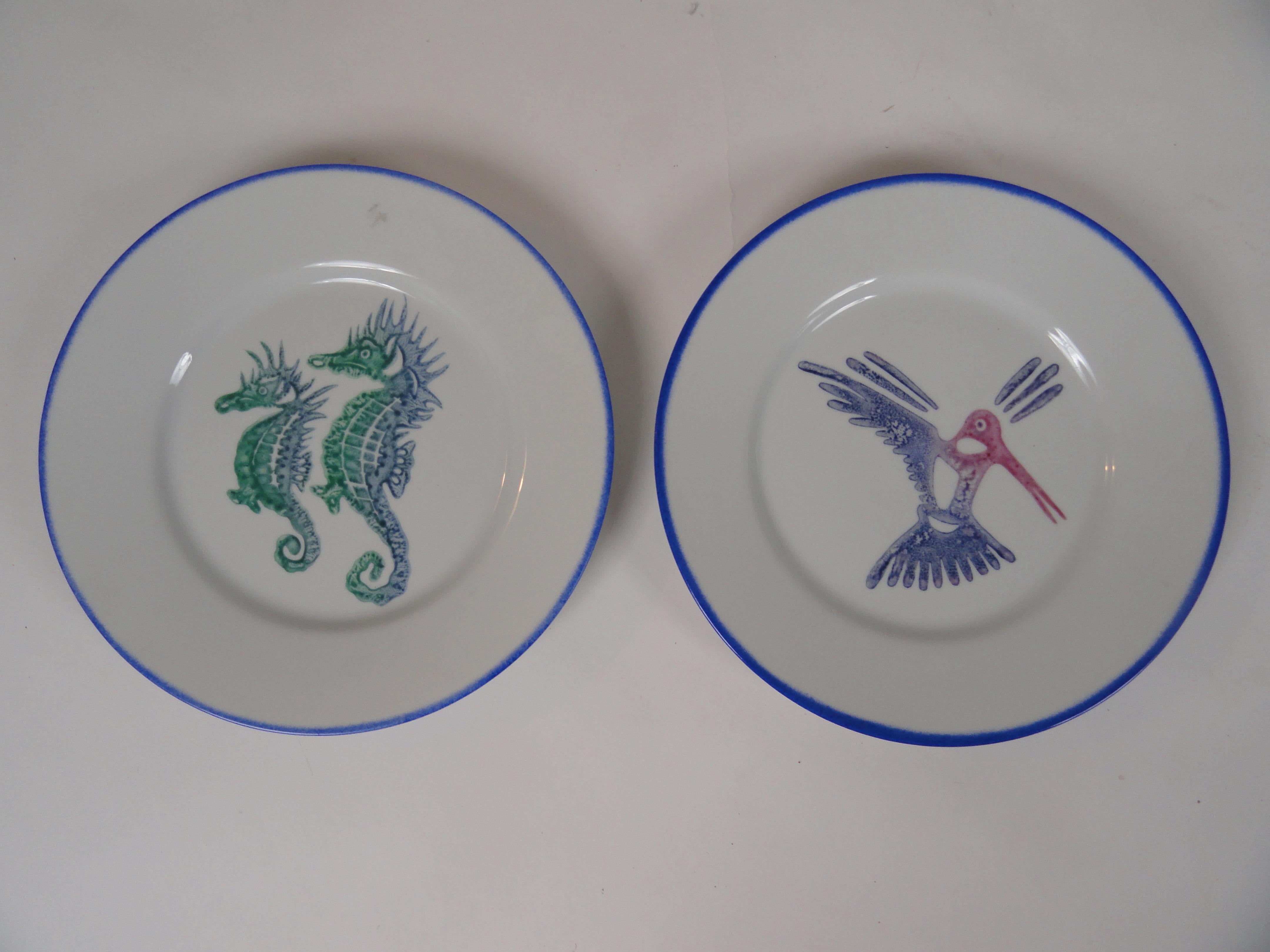 Limoges France porcelain plates with original drawings by Jean Yves Froment, artist from St. Barths. 
Plates feature colorful birds and sea life. Seven Larger plates and 3 smaller plates. Plates have green, yellow and blue borders.
Larger plates