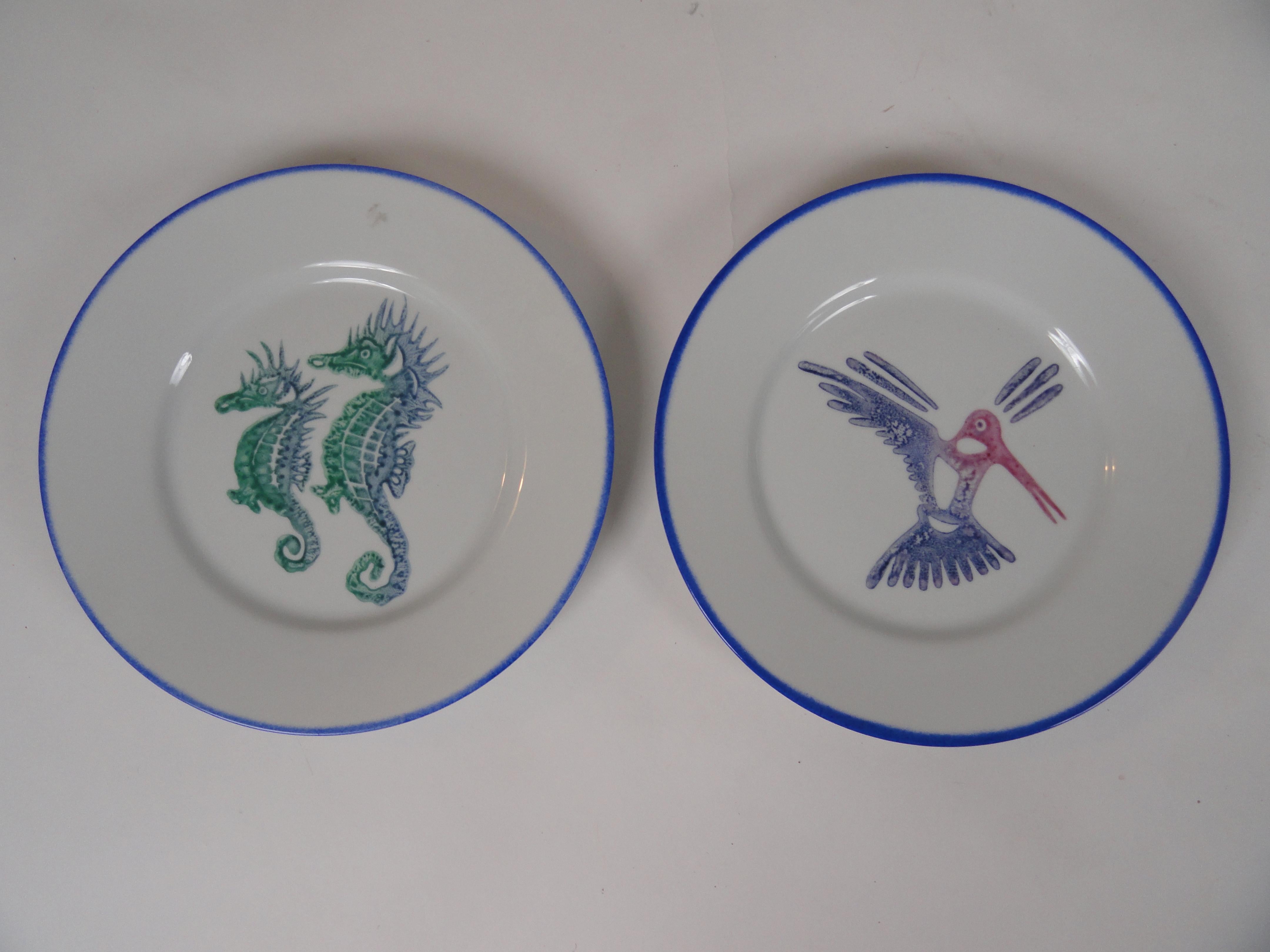 Limoges, France porcelain plates with original drawings by Jean Yves Froment, an artist from St. Barths. Plates feature colorful birds and sea life. Seven larger plates and 3 smaller plates. Plates have green, yellow and blue borders.