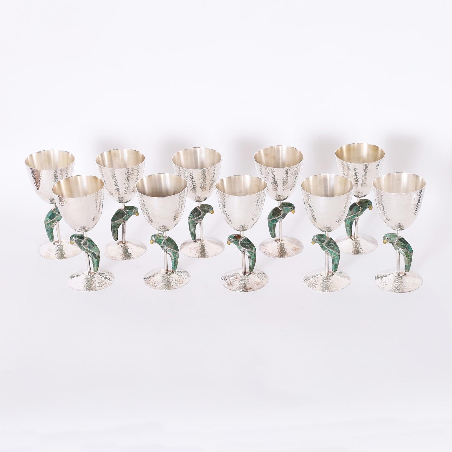 Rare and remarkable set of ten mid century goblets crafted in silver plate over hand hammered copper featuring stone clad parrots on the stems. Signed Los Castillo on the bottoms.