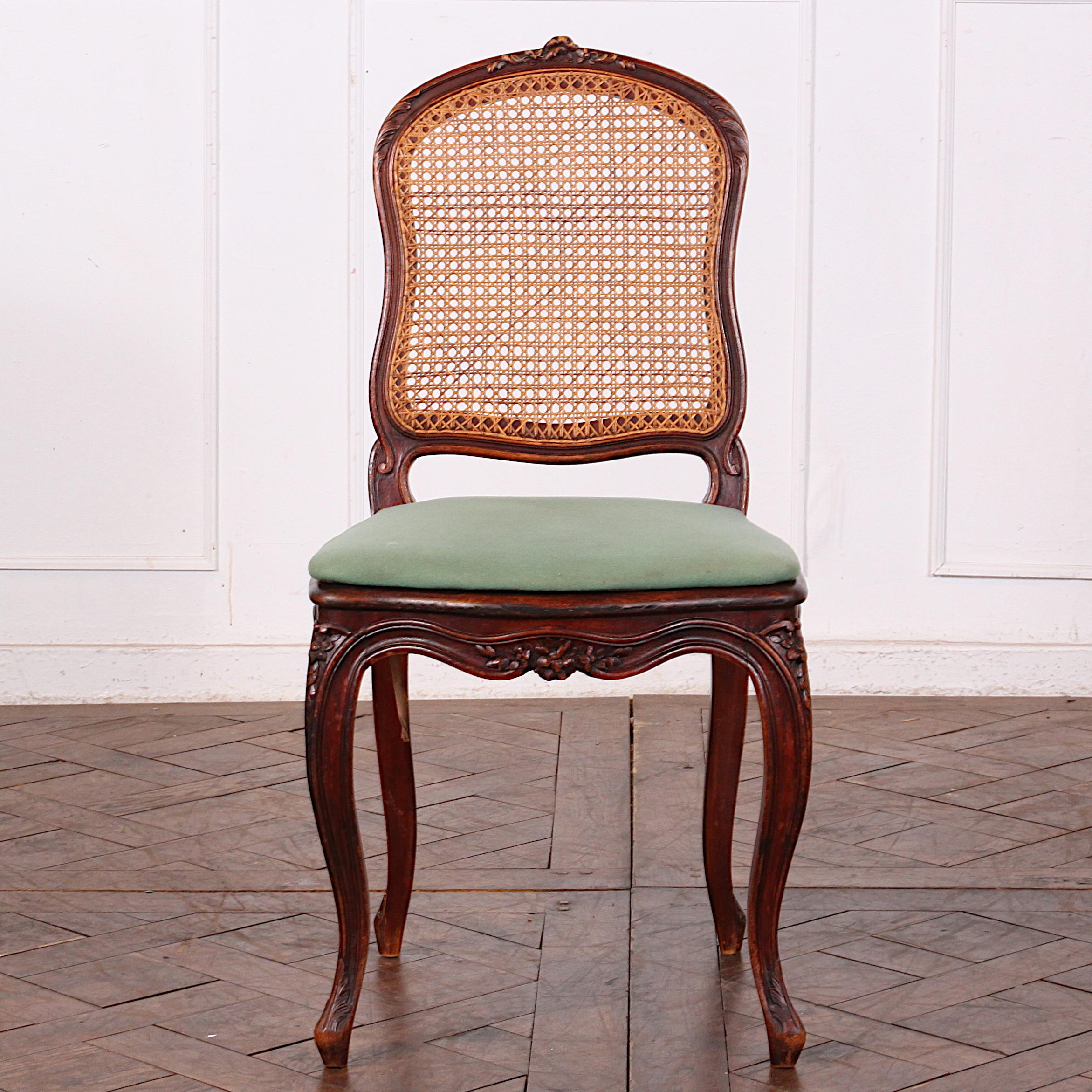 Set of ten Louis XV style caned dining chairs with green fabric seats.