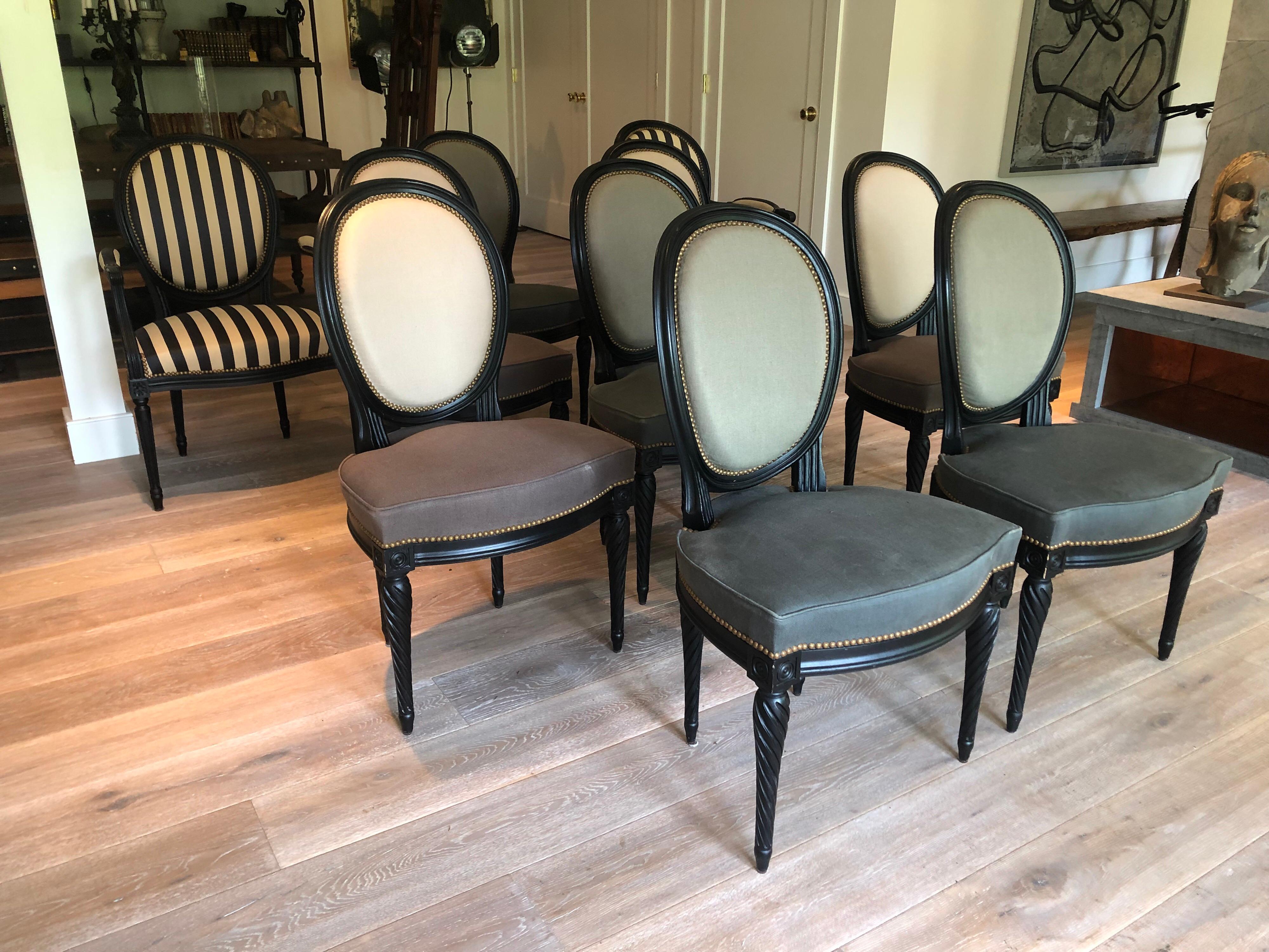 A set of eight custom Louis XVI style dining chairs. Each upholstered in alternating fabrics and black painted wood frames. Side chairs with natural and dark grey upholstery and coordinating grey upholstery with light grey. From a New York City