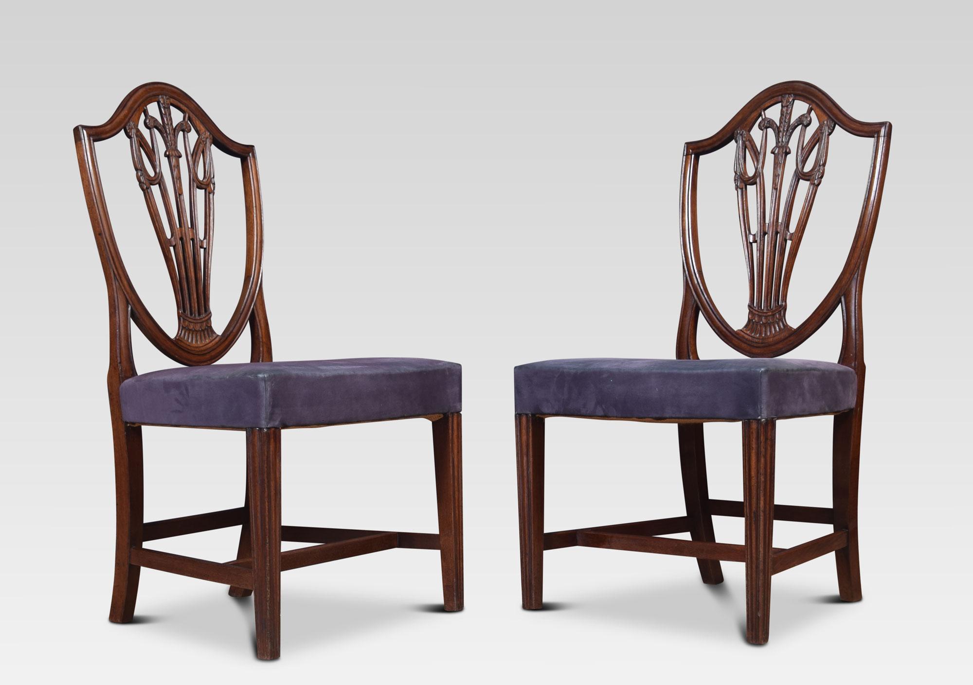 A set of ten very good quality mahogany Hepplewhite style dining chairs. Having pierced wheatsheaf carved splats above upholstered overstuffed seats the upholstery has some marks but is serviceable. All raised up on square tapering front legs